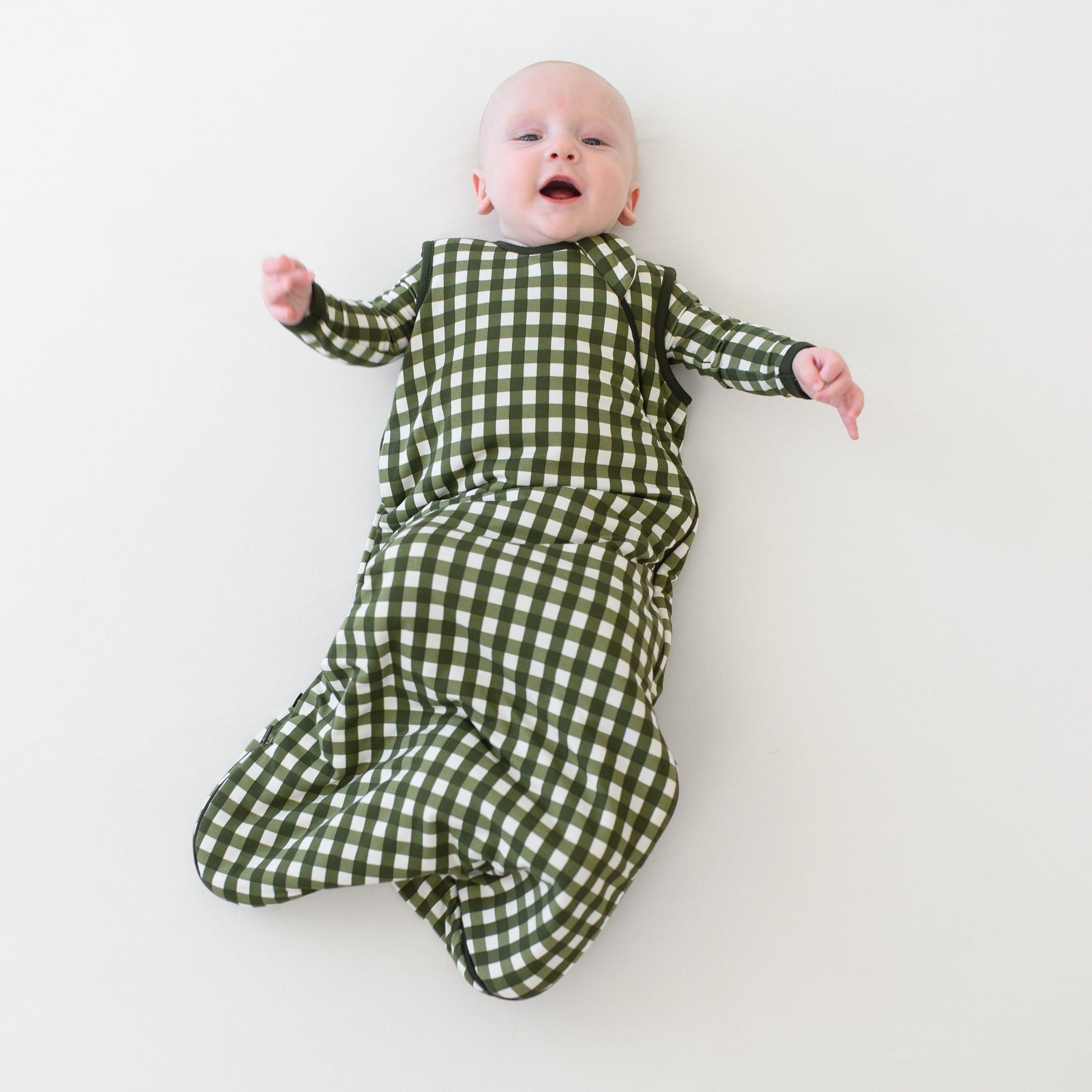 Infant wearing Sleep Bag in green Gingham Fir 1.0 TOG with long sleeve pajamas
