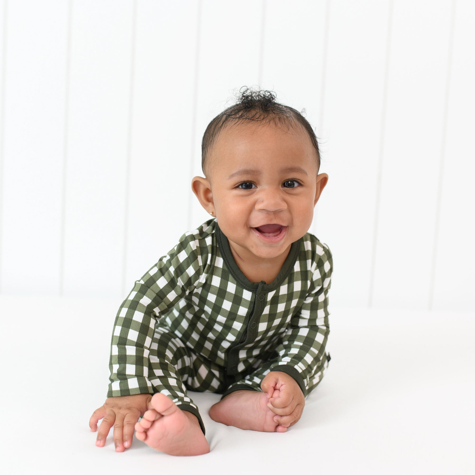 Smiling infant sitting wearing the Romper in Gingham Fir