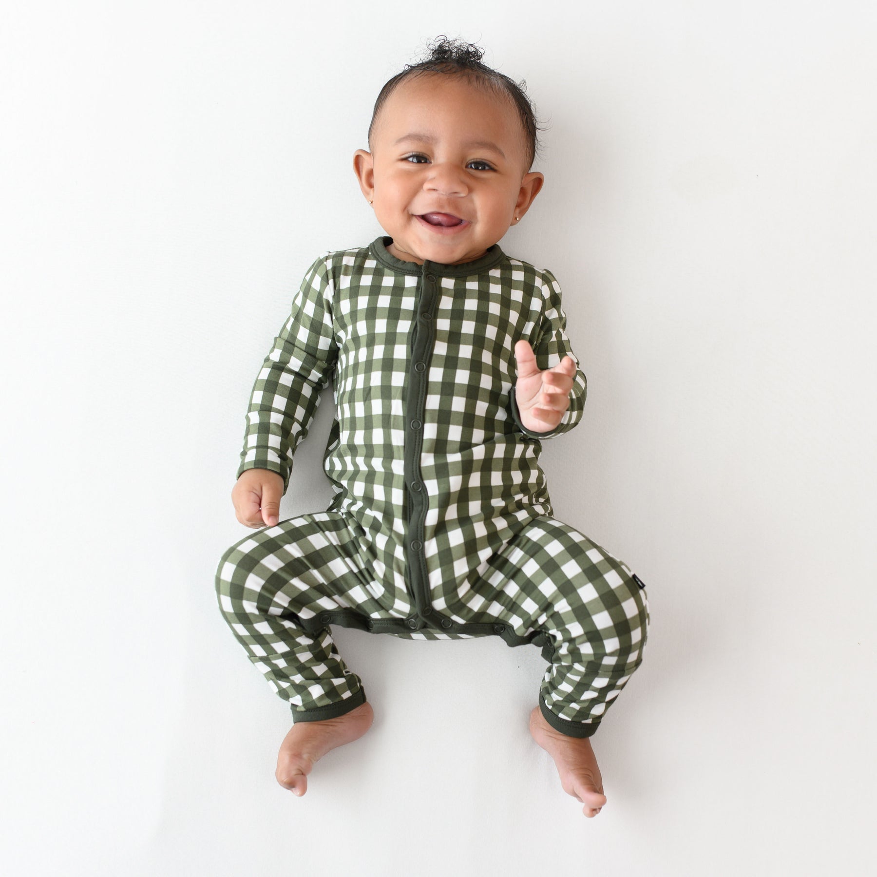 infant laying down wearing the Romper in Gingham Fir