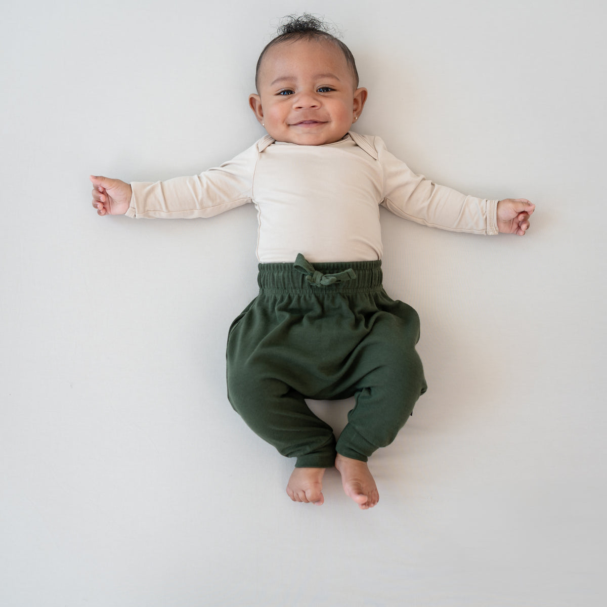 Infant wearing Bamboo Jersey Harem Pants in Fir with Bisque long sleeve onesie