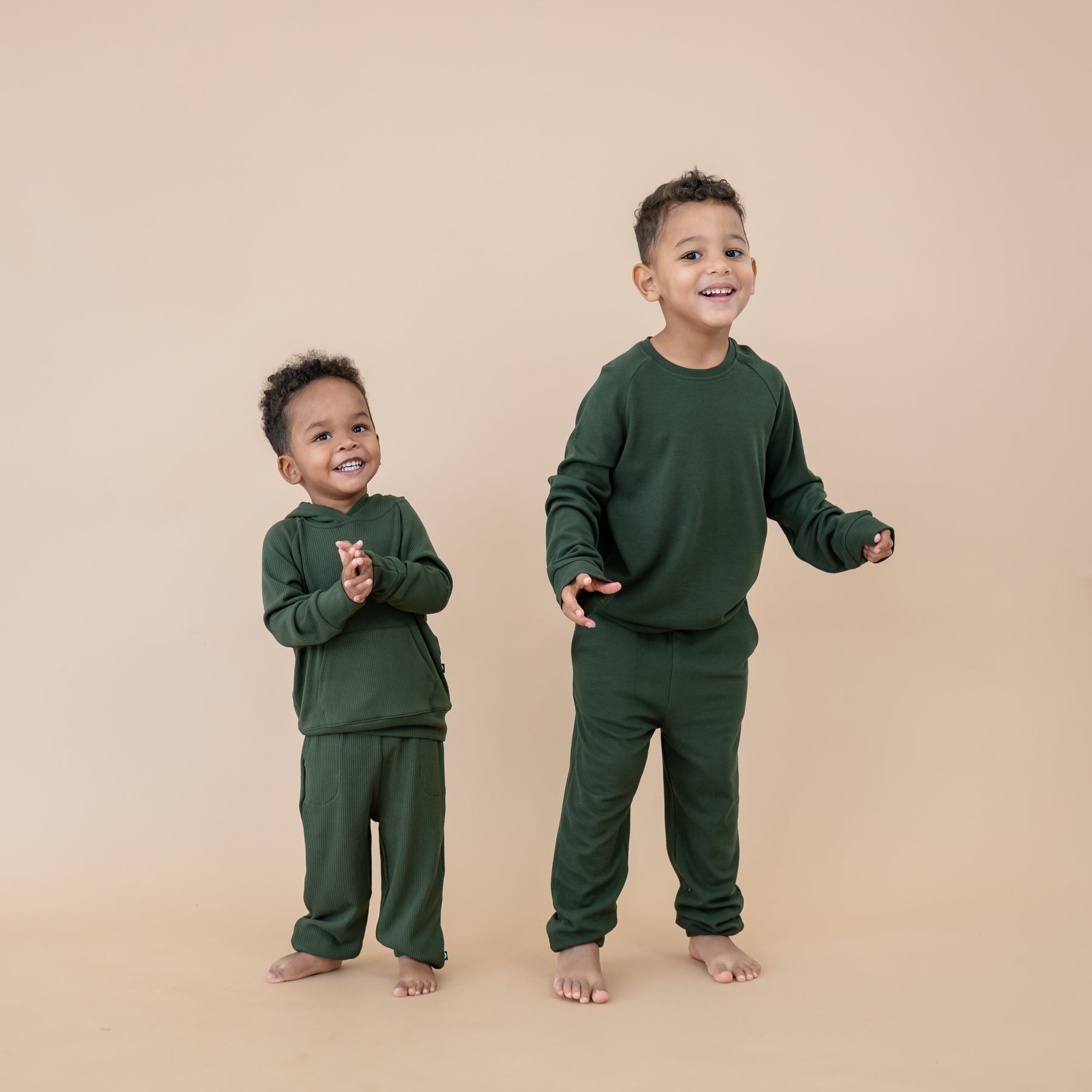 Boys wearing matching sibling pajamas in Fir green