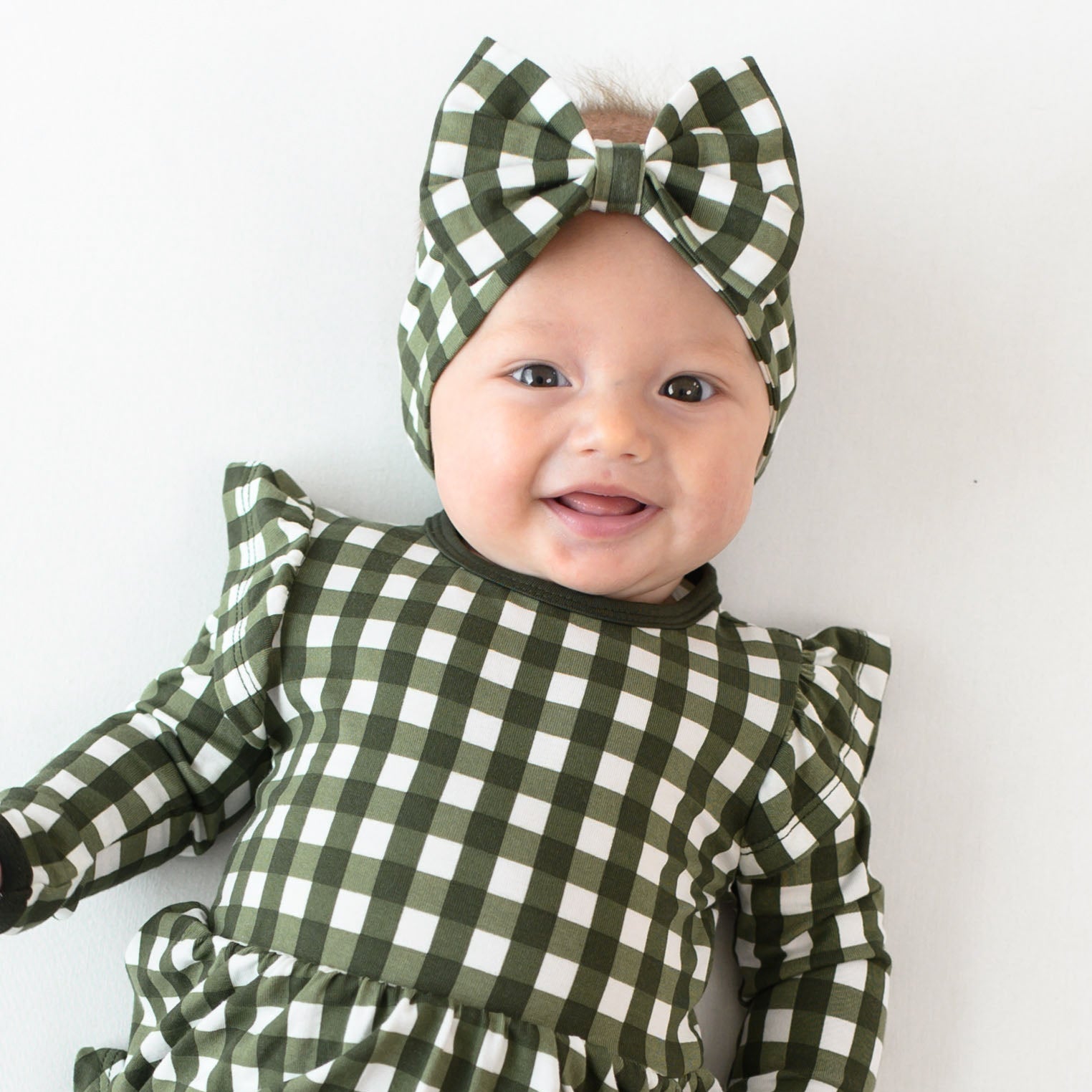 Baby wearing Bow Headband in Gingham Fir with matching Christmas dress