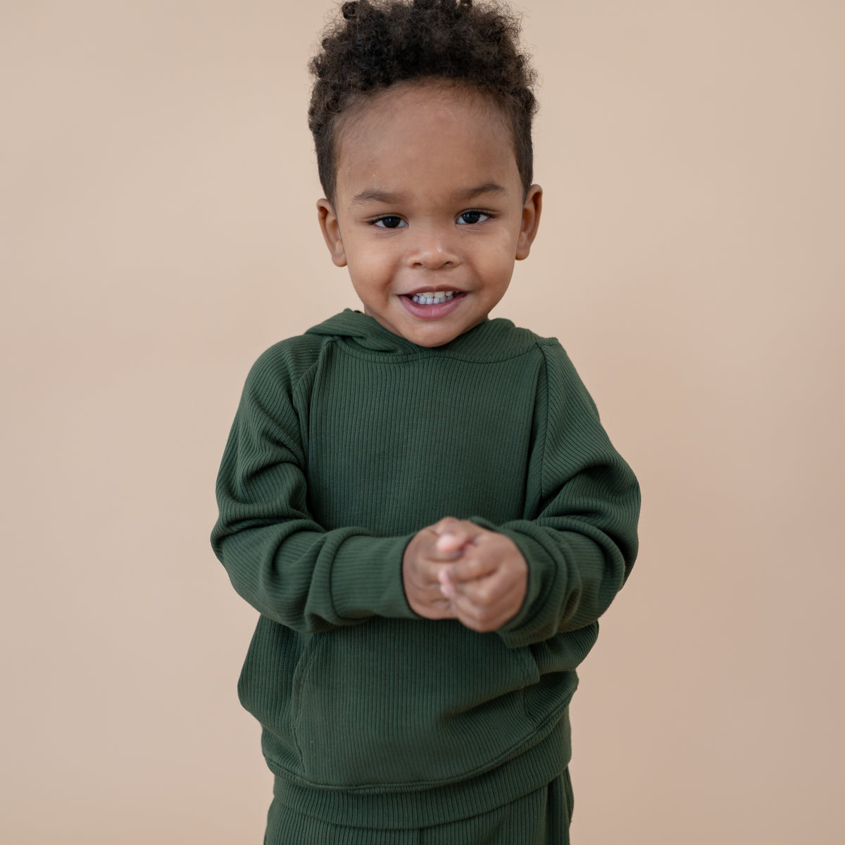 Close up of the Ribbed Hoodie in Fir shown on a young model