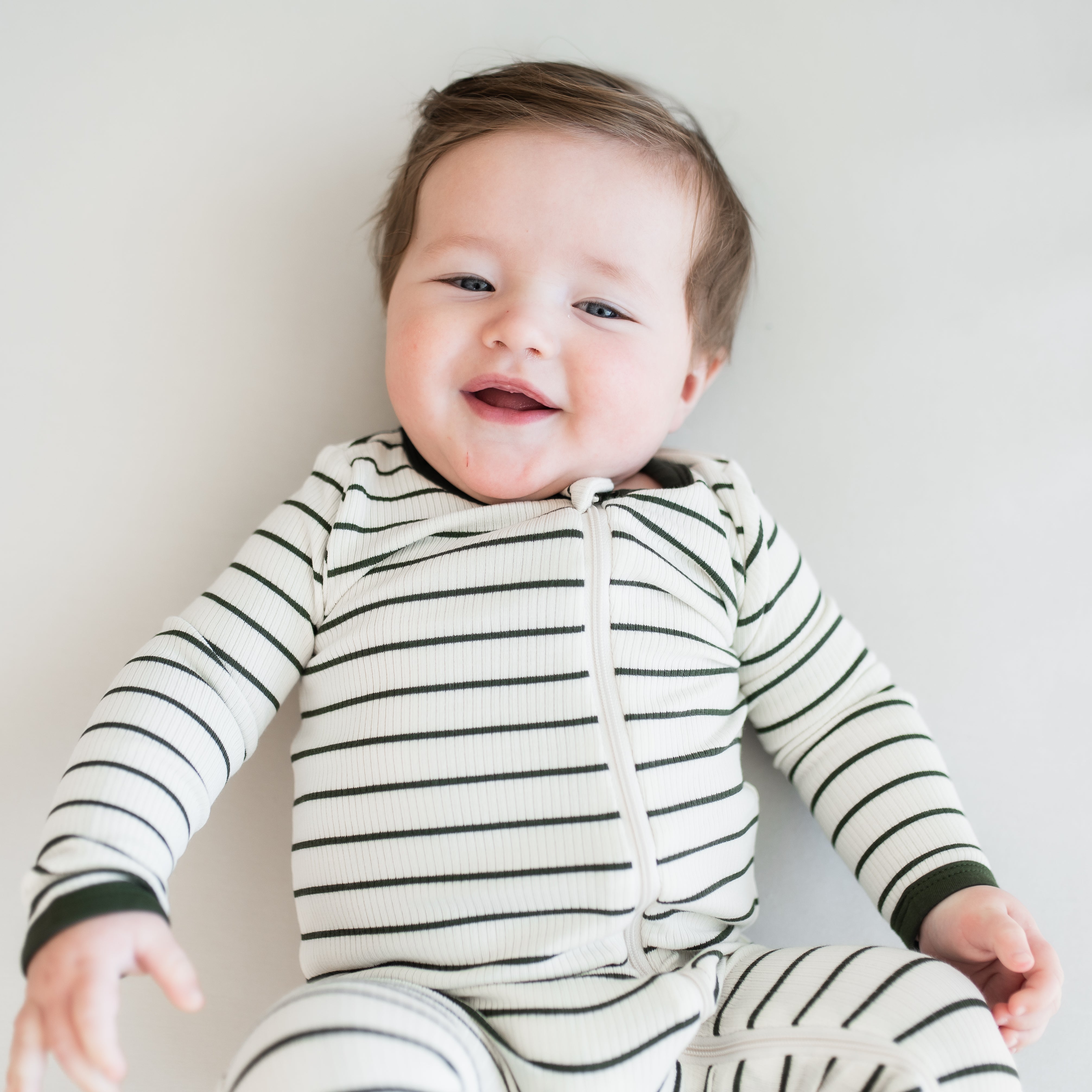 Close up of the Ribbed Zipper Romper in Fir Stripe on an infant