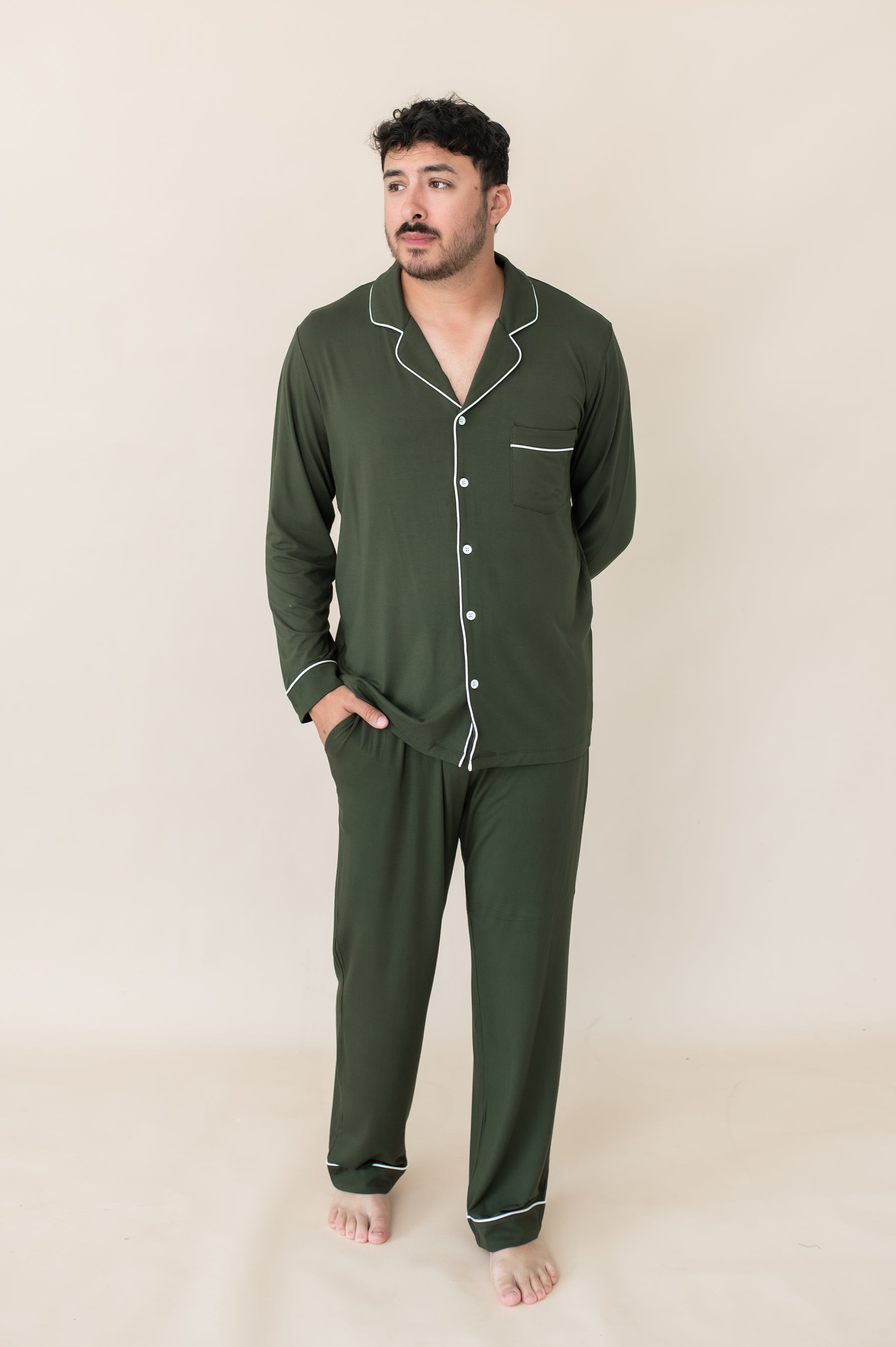 Male model wearing the Men's Long Sleeve Pajama Set in Fir with one hand in the pants pocket and the other behind his back