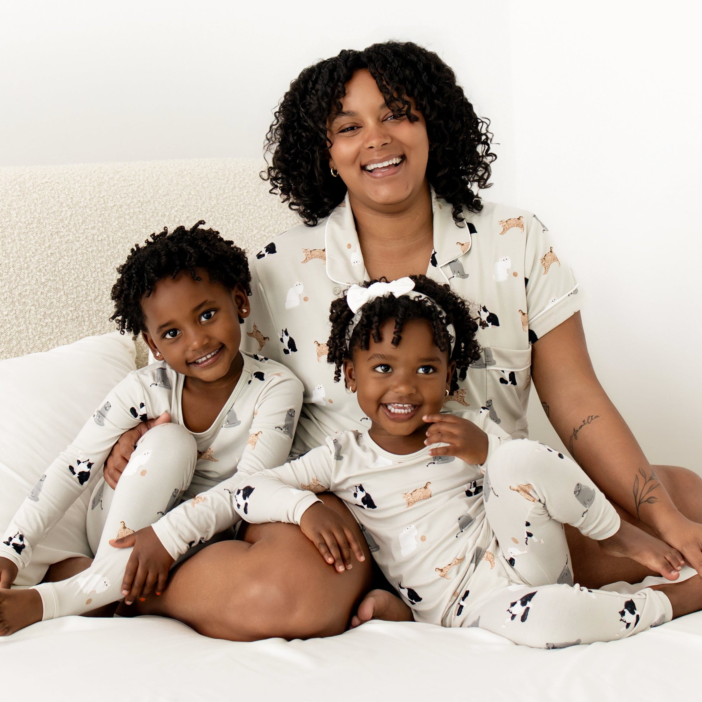 Mom and 2 kids wearing matching cat pajamas