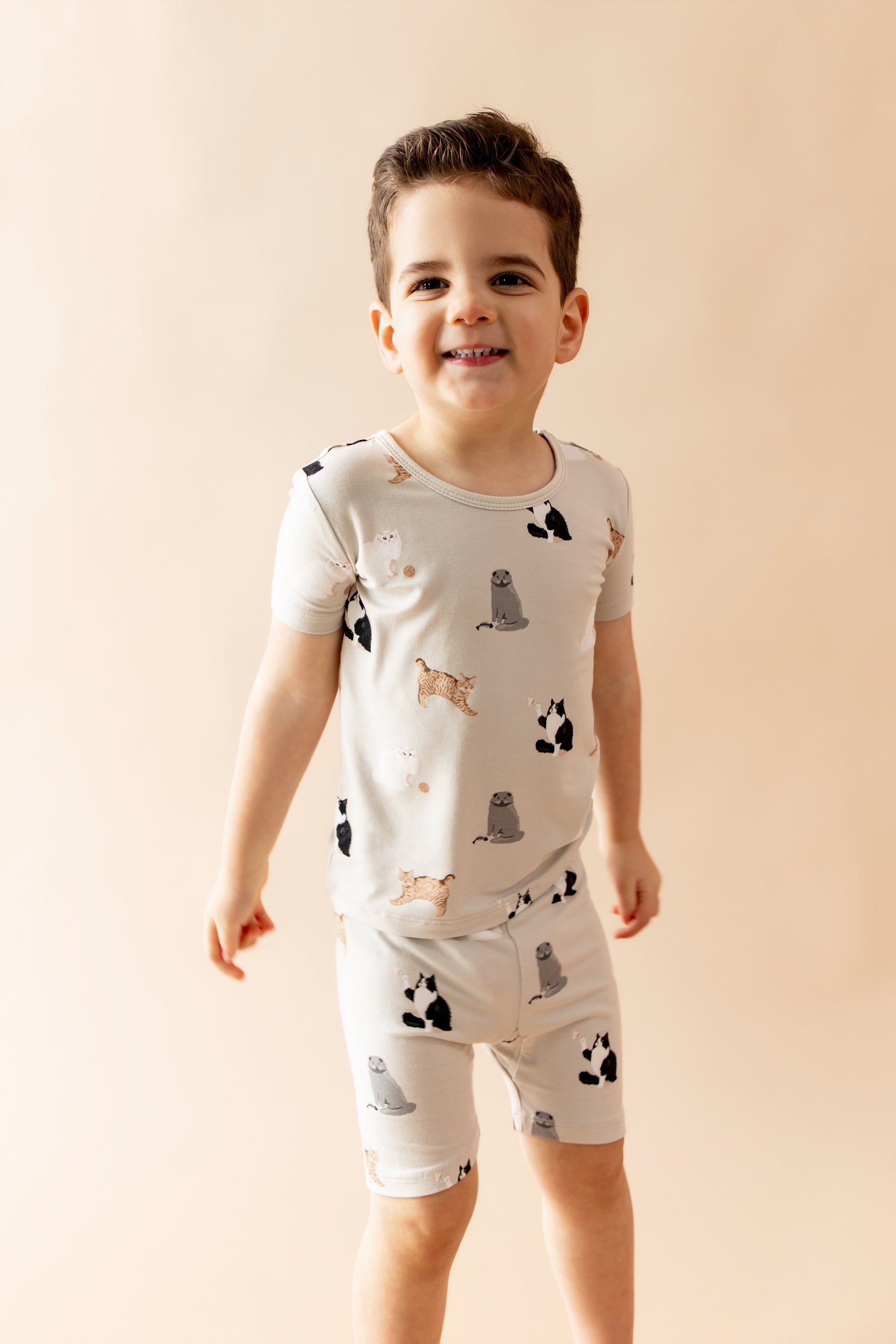 Young boy wearing the Short Sleeve Pajamas in Fluffy Cat