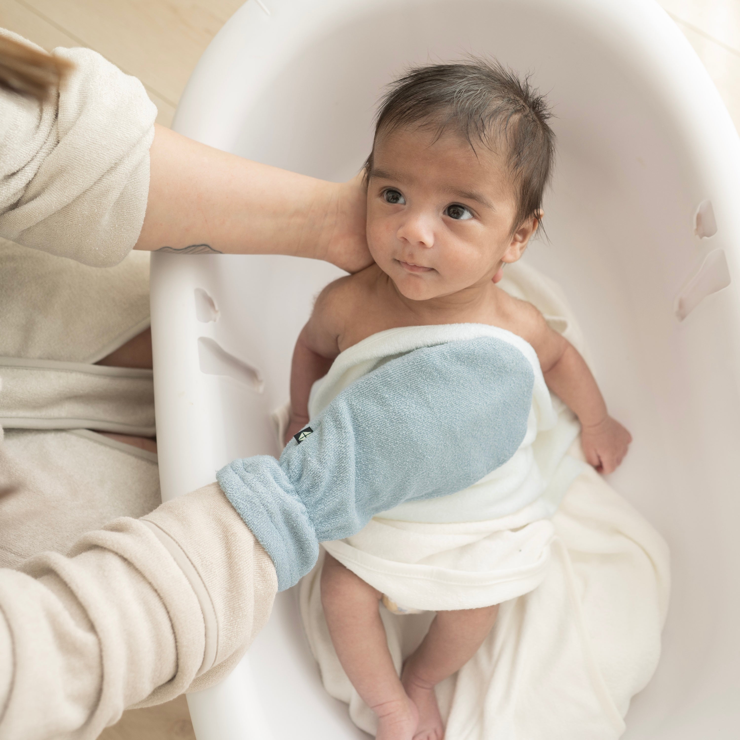 Parent using Bamboo Terry Bath Mitt in Fog Blue to bathe newborn