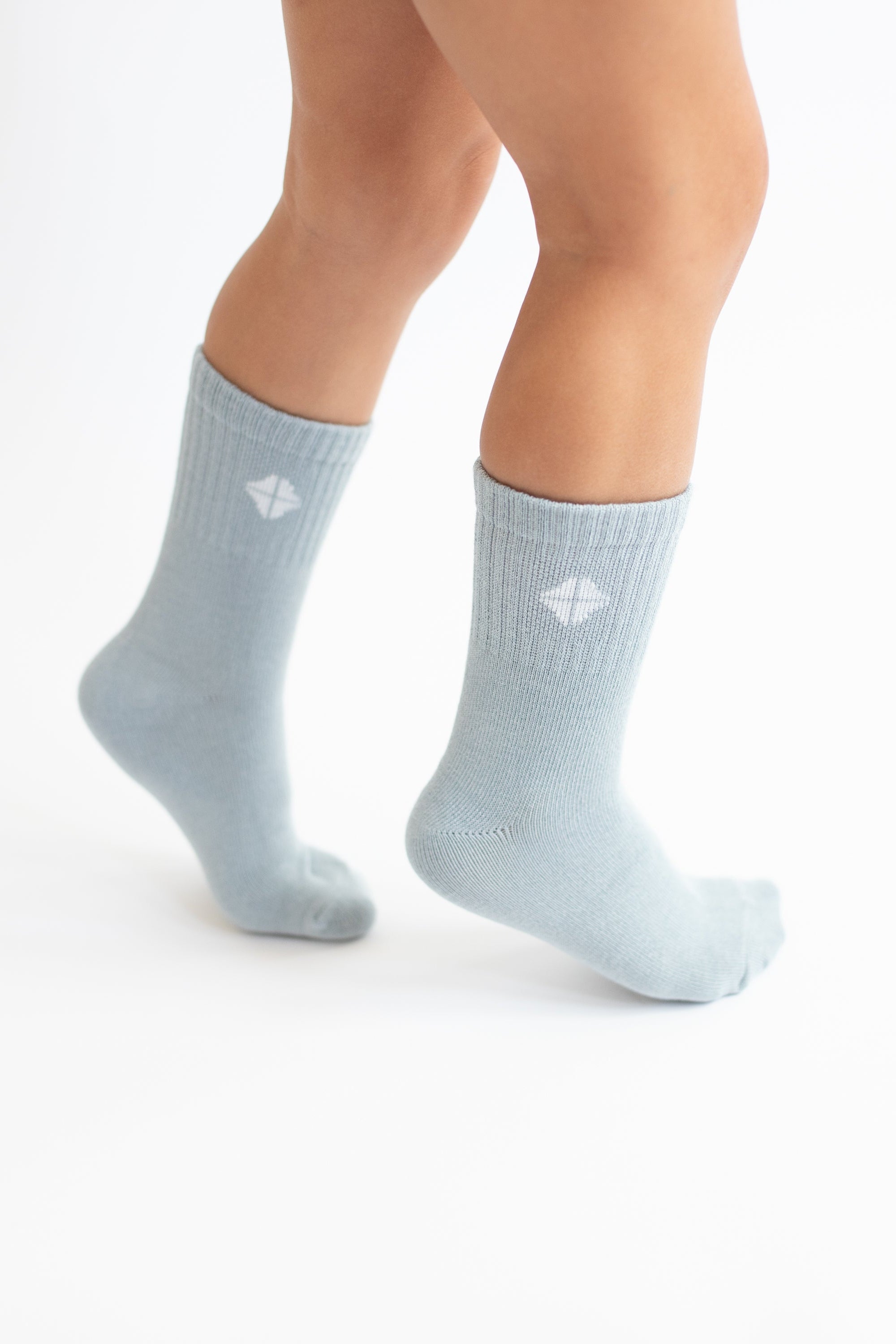 Crew Socks in Fog shown on a toddler model with the Kyte Baby logo visible
