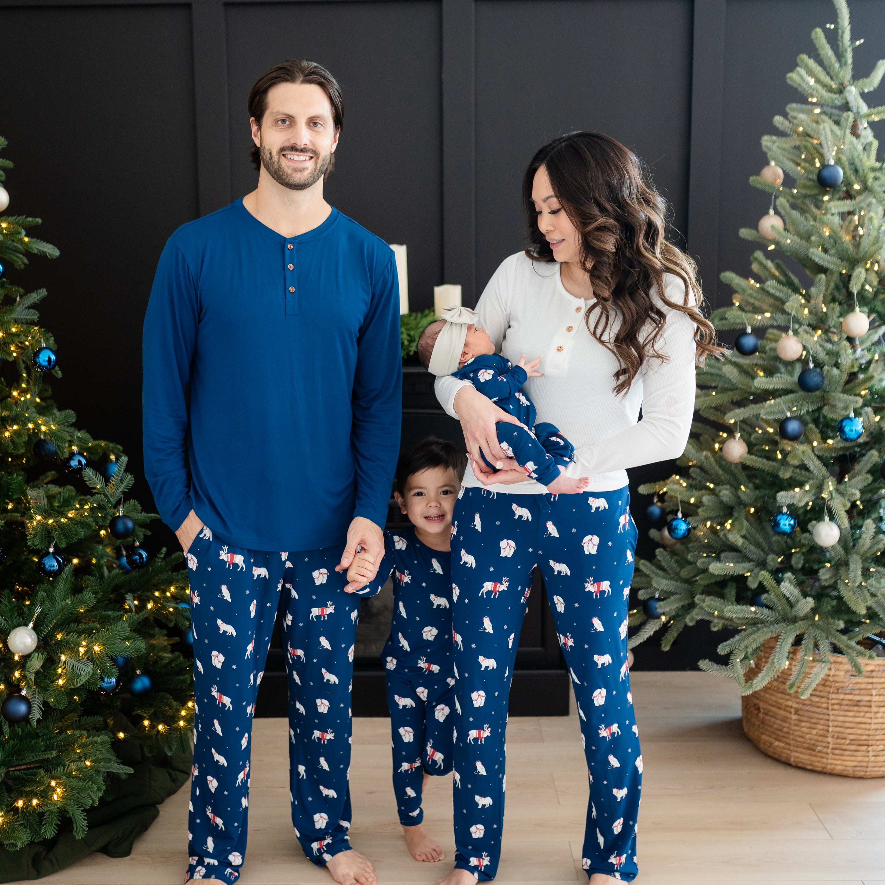 Family of four wearing Frosty Friends items. Father is wearing his lounge pants paired with the Men's Long Sleeve Henley Top in Tahoe