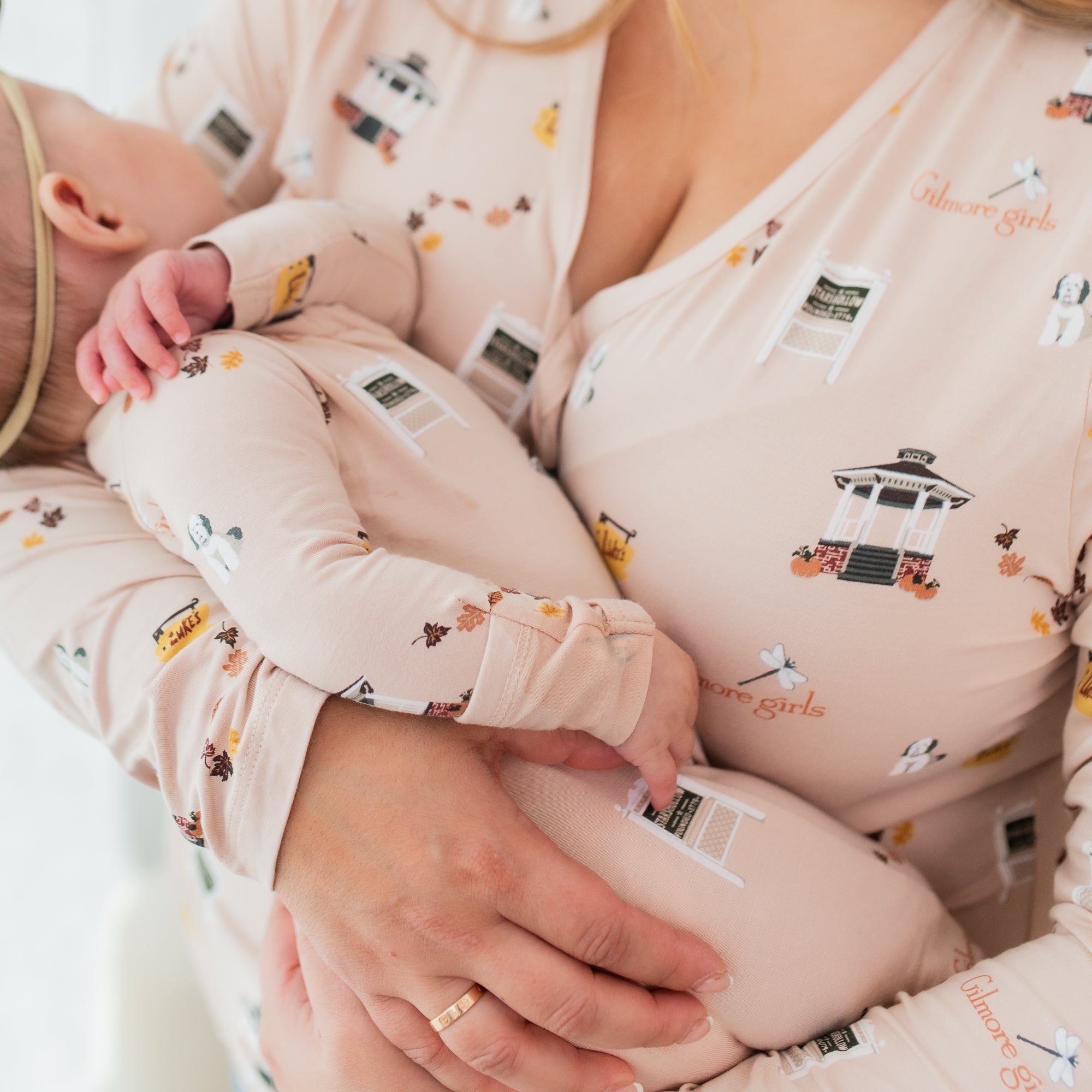 Close up of the Women's Long Sleeve Henley Tee in Gilmore Girls showing the front button closures shown on a model holding her infant girl who is wearing a matching romper
