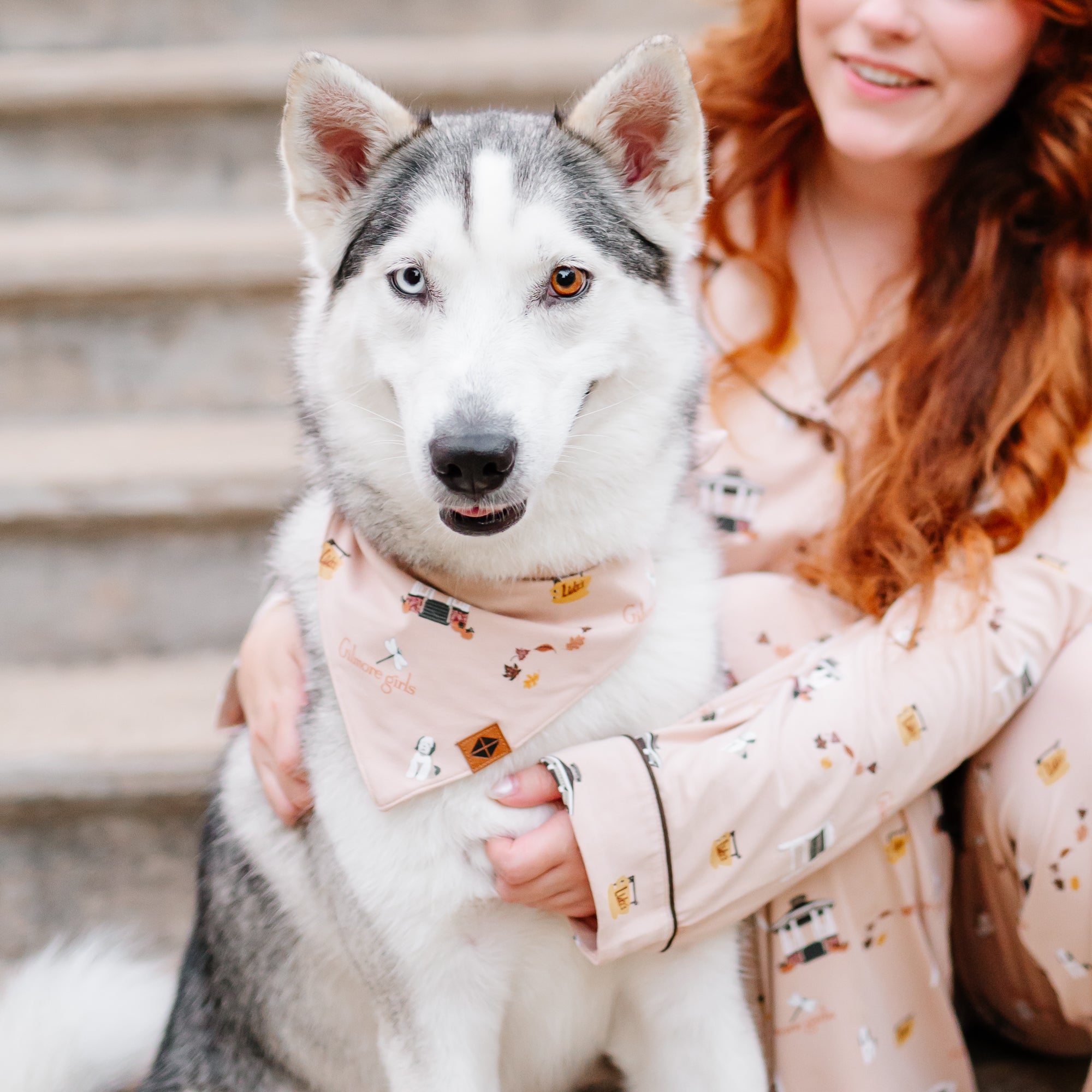 Female model wearing the long sleeve women's pajama set in gilmore girls sitting on stairs beside a husky wearing the Dog Bandana in Gilmore Girls