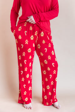 Modal wearing women's lounge pants in gingerbread print over red T-shirt on a beige background