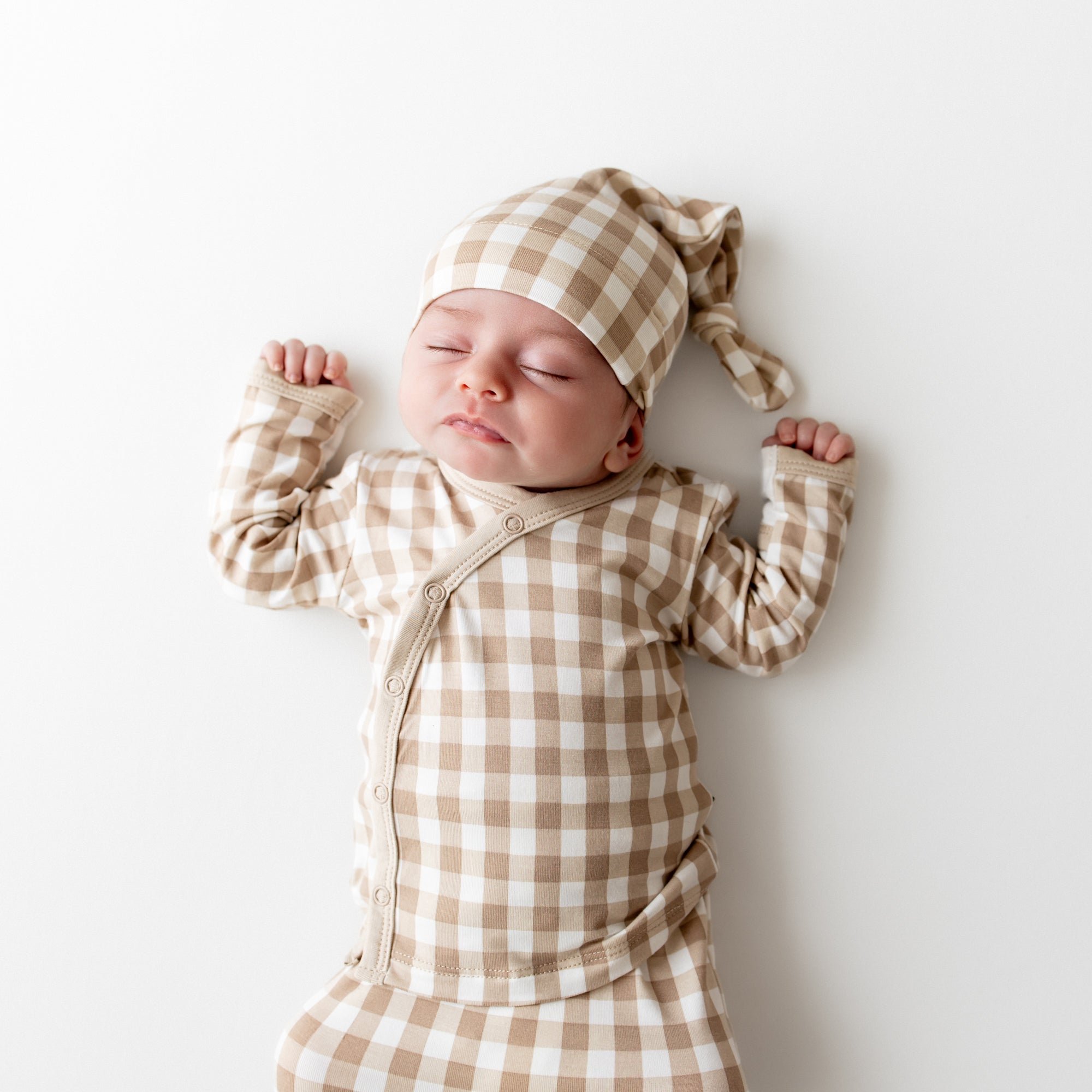 Close up of sleeping infant wearing the Take Me Home Set with Cap in Gingham Bisque