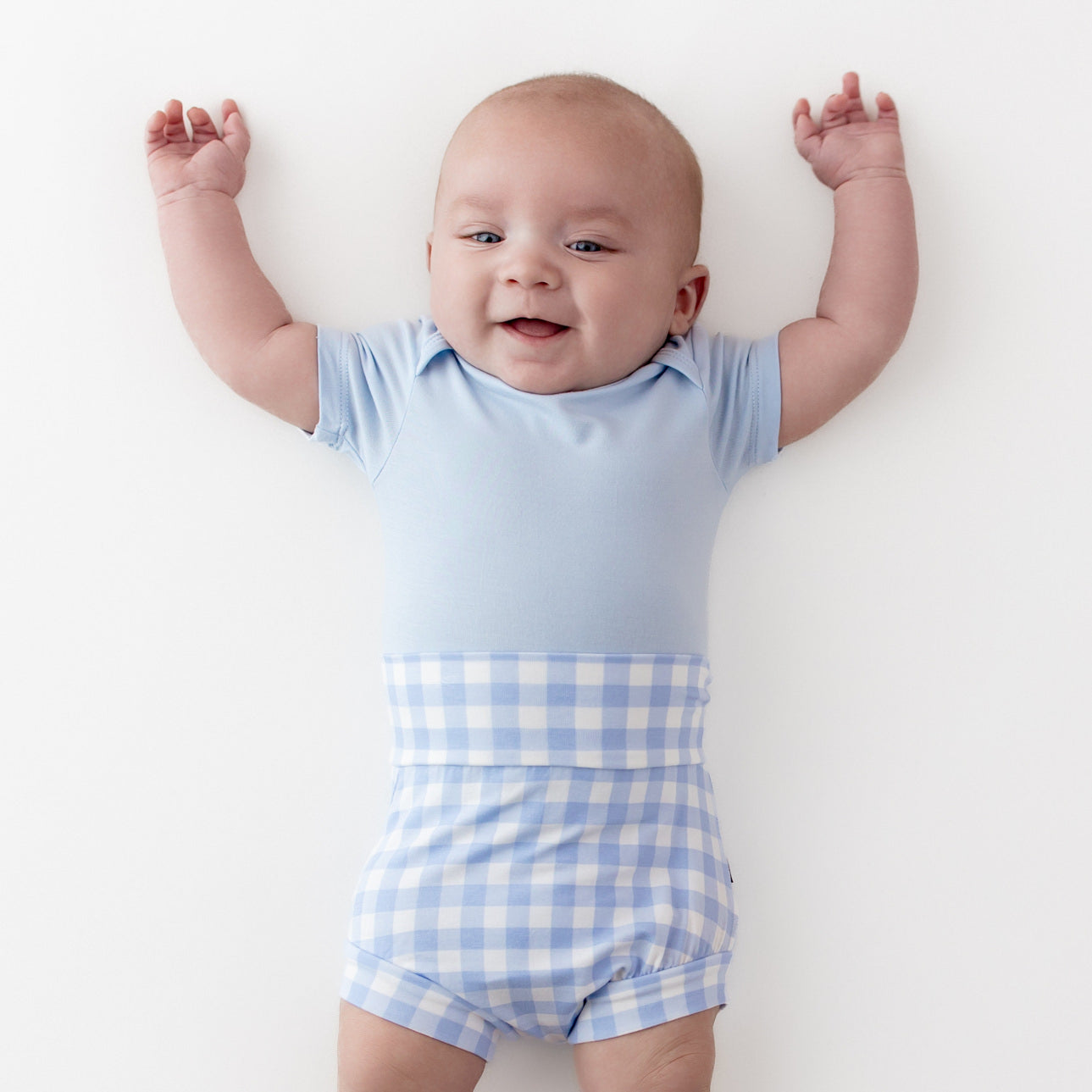 Close up of infant wearing the Bummies in Gingham Breeze with light blue short sleeve bodysuit
