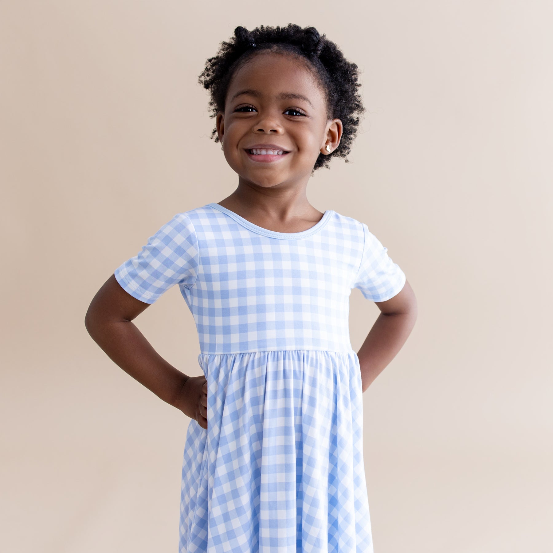 Close up of smiling girl wearing the Twirl Dress in Gingham Breeze