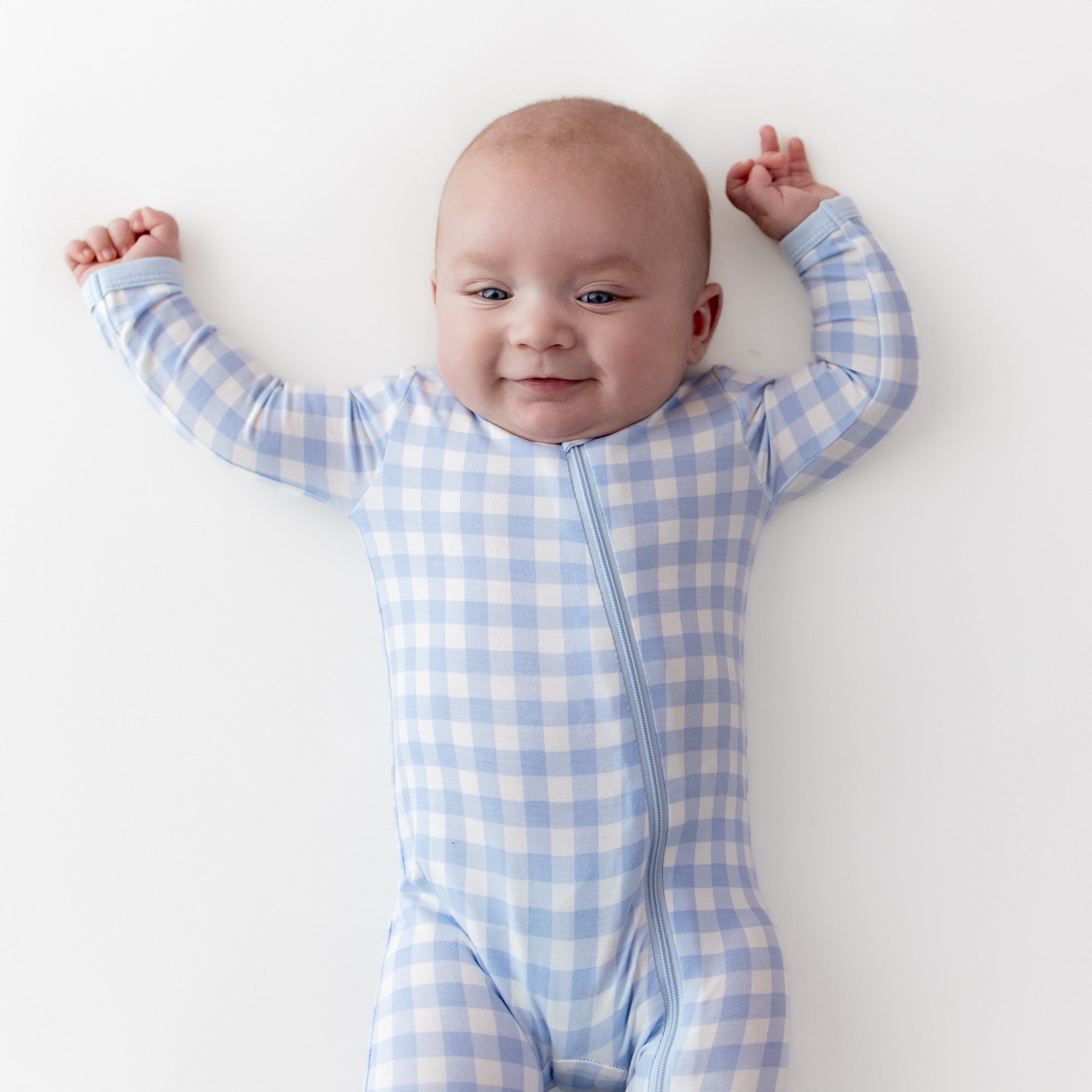 Close up of an infant wearing the Zippered Romper in Gingham Breeze