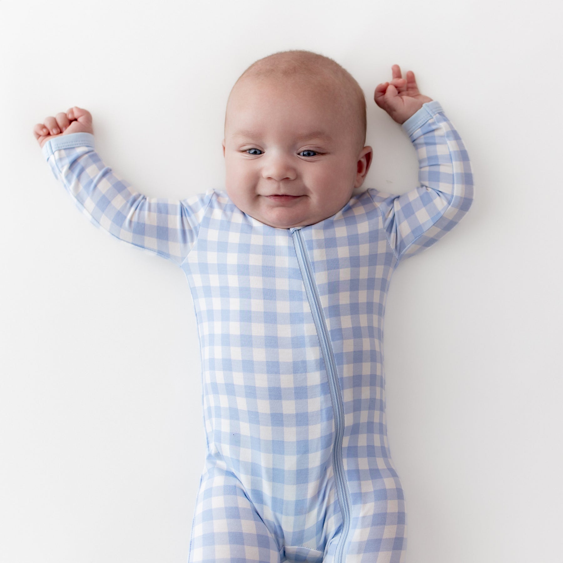 Close up of an infant wearing the Zippered Romper in Gingham Breeze