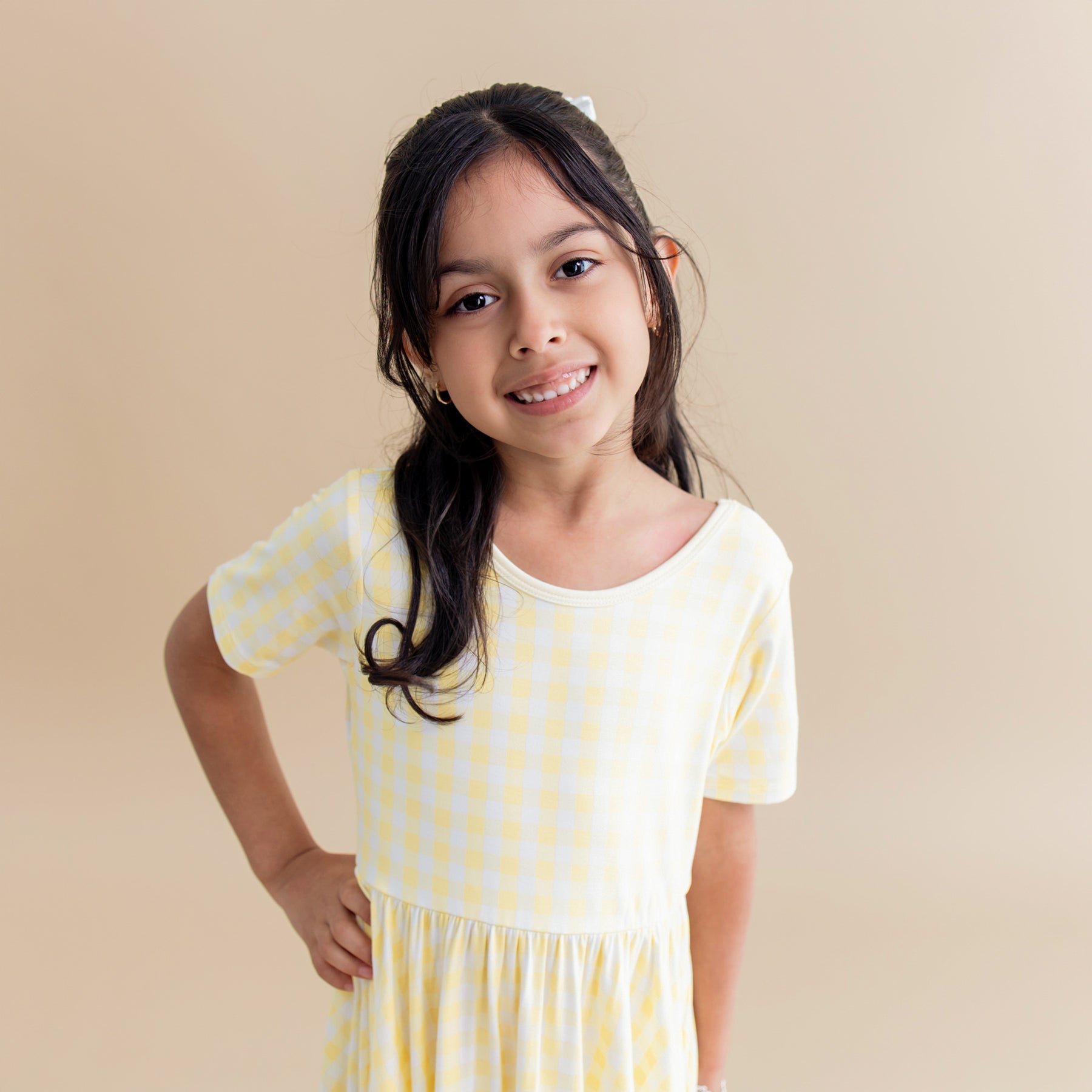 Close up of young girl wearing the Twirl Dress in Gingham Chamomile