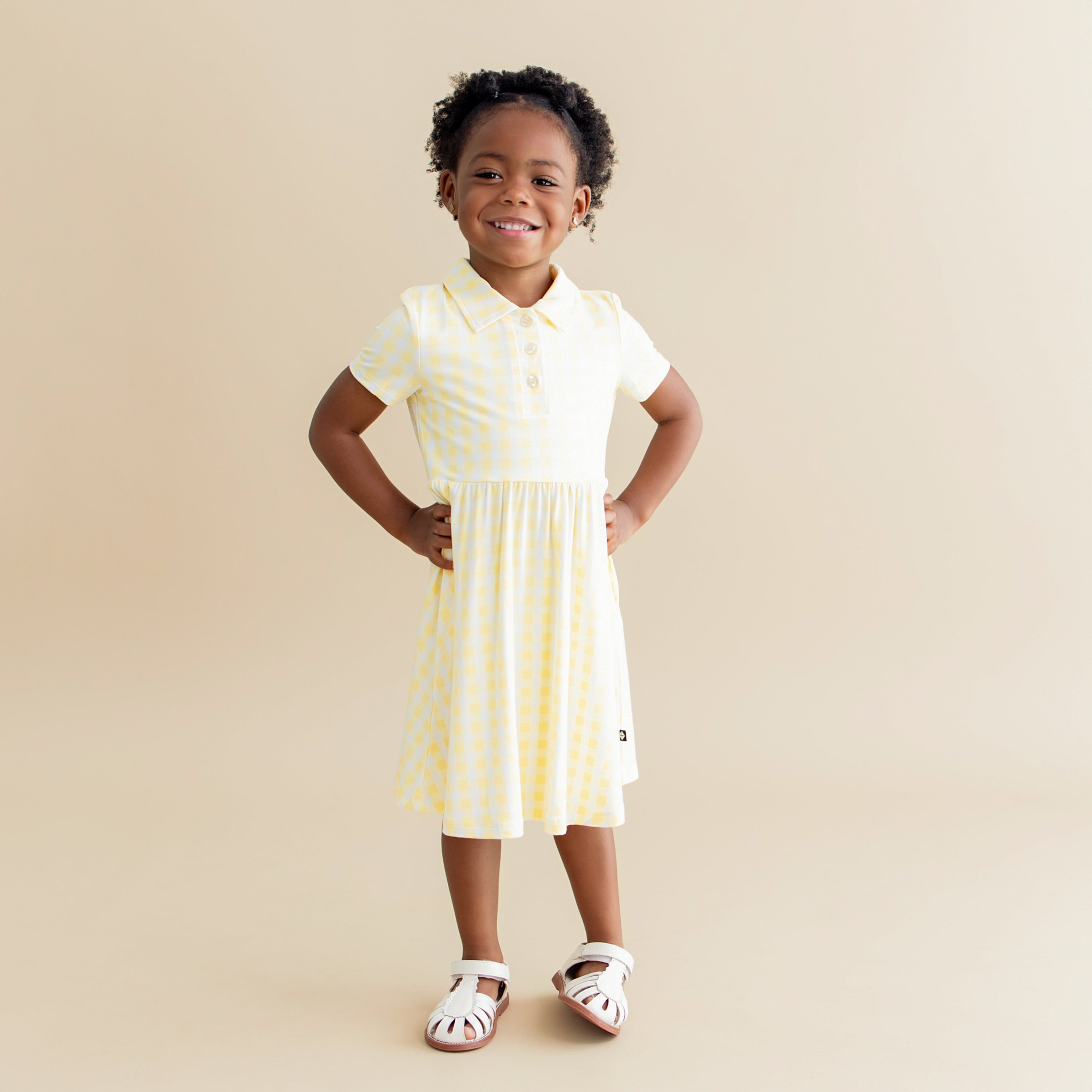 Young girl posing wearing the Polo Dress in Gingham Chamomile