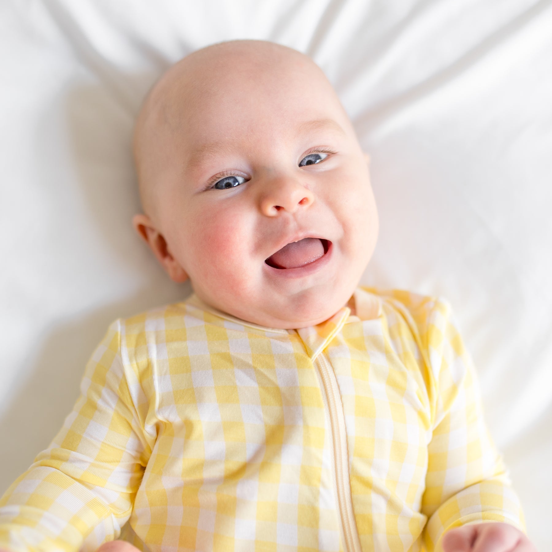 Close up of infant wearing the Zippered Romper in Gingham Chamomile