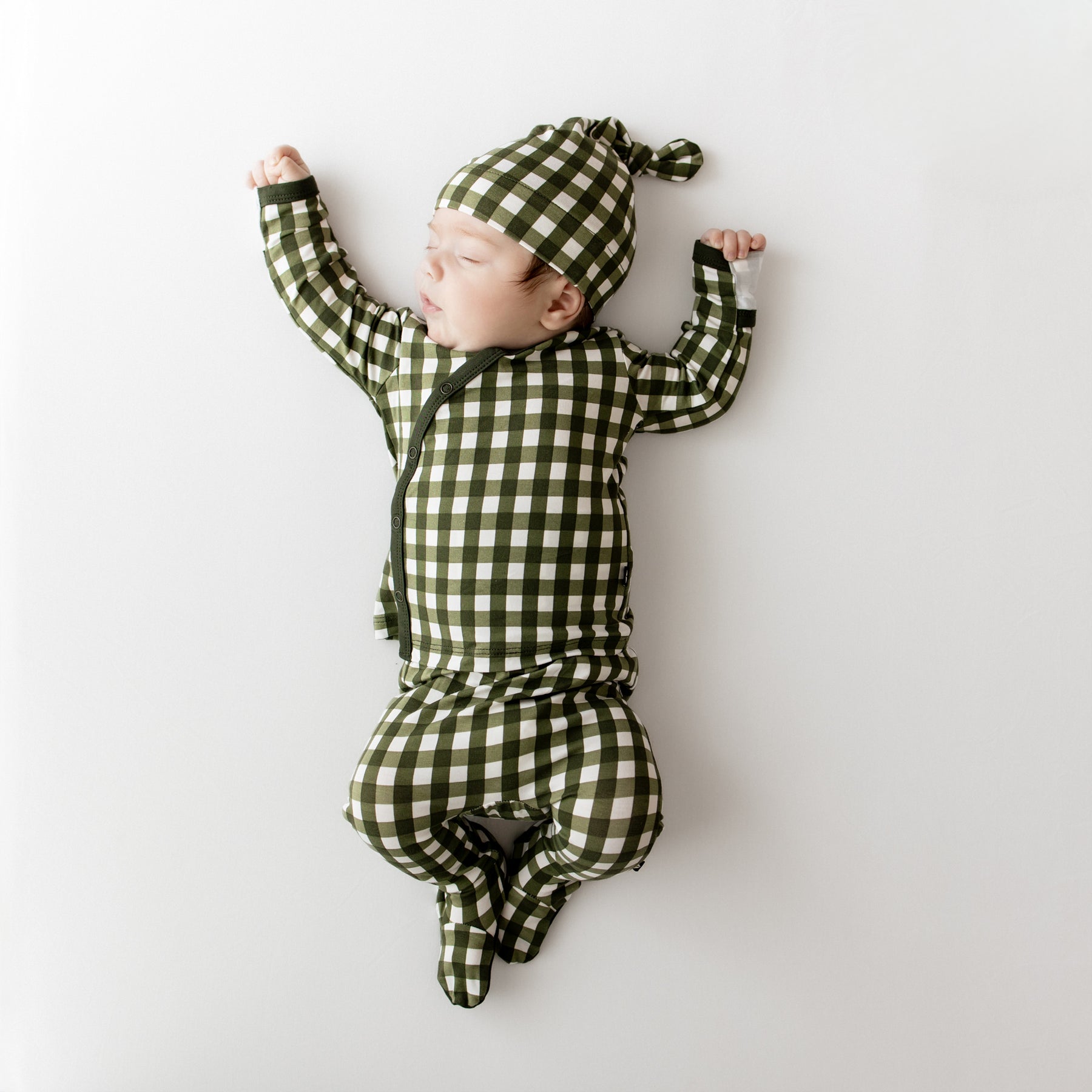 Sleeping infant wearing the Take Me Home Set with Cap in Gingham Fir