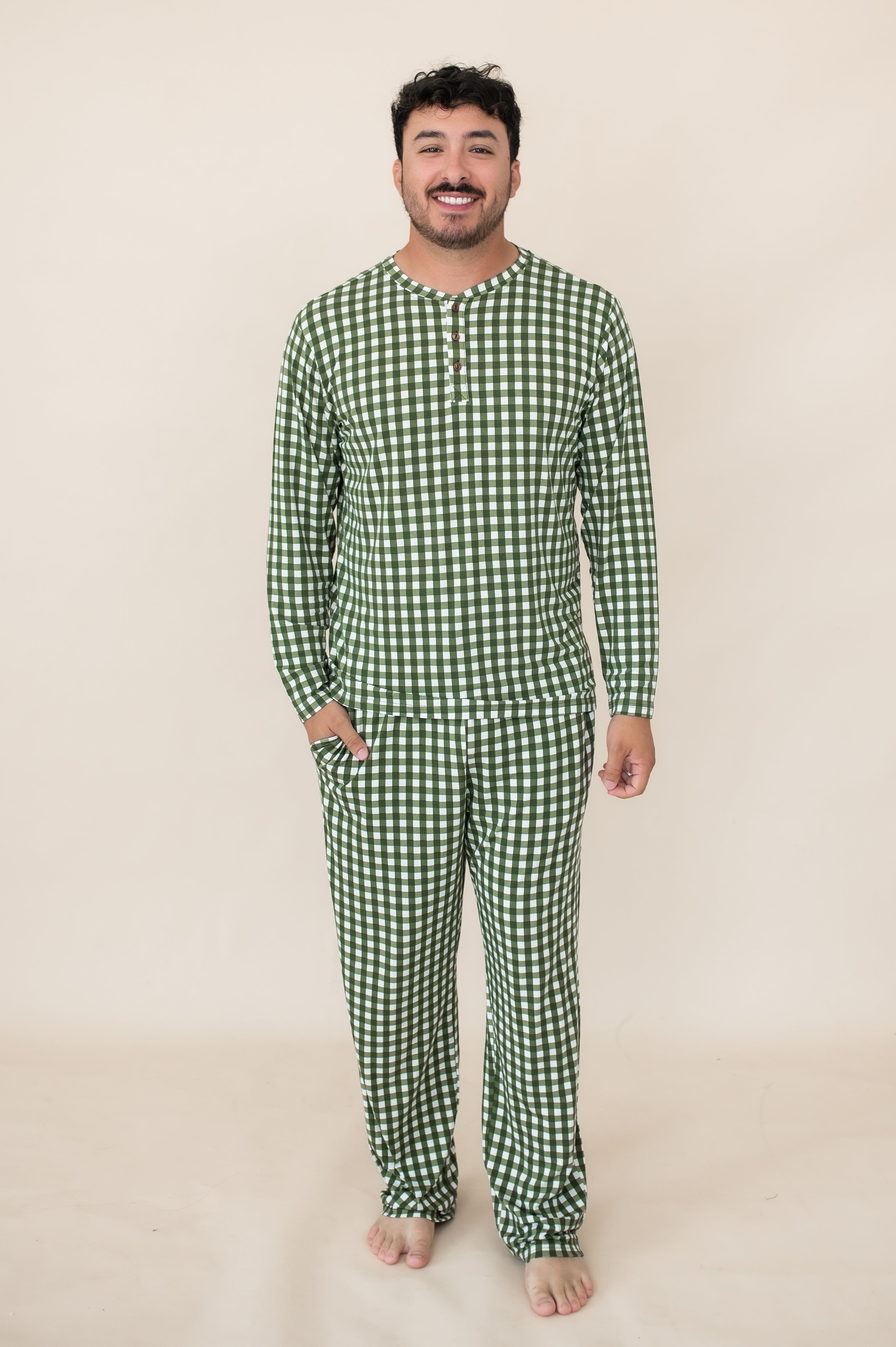 Male model wearing the Men's Long Sleeve Henley Top in Gingham Fir paired with matching men's lounge pants