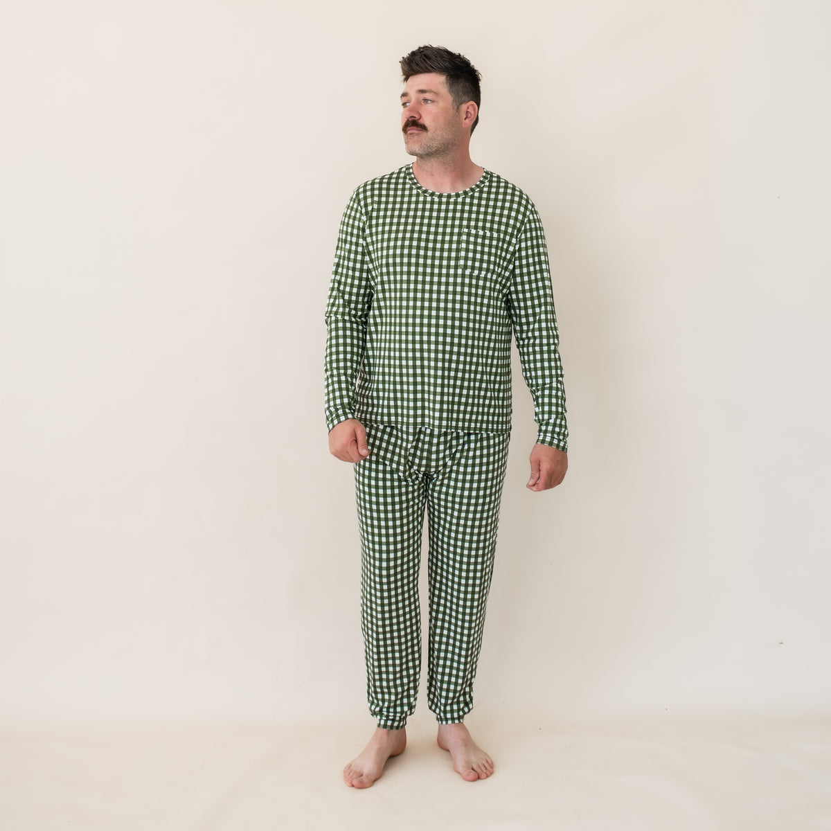 Male model wearing the Men's Jogger Set in Gingham Fir standing in front of a light beige backdrop