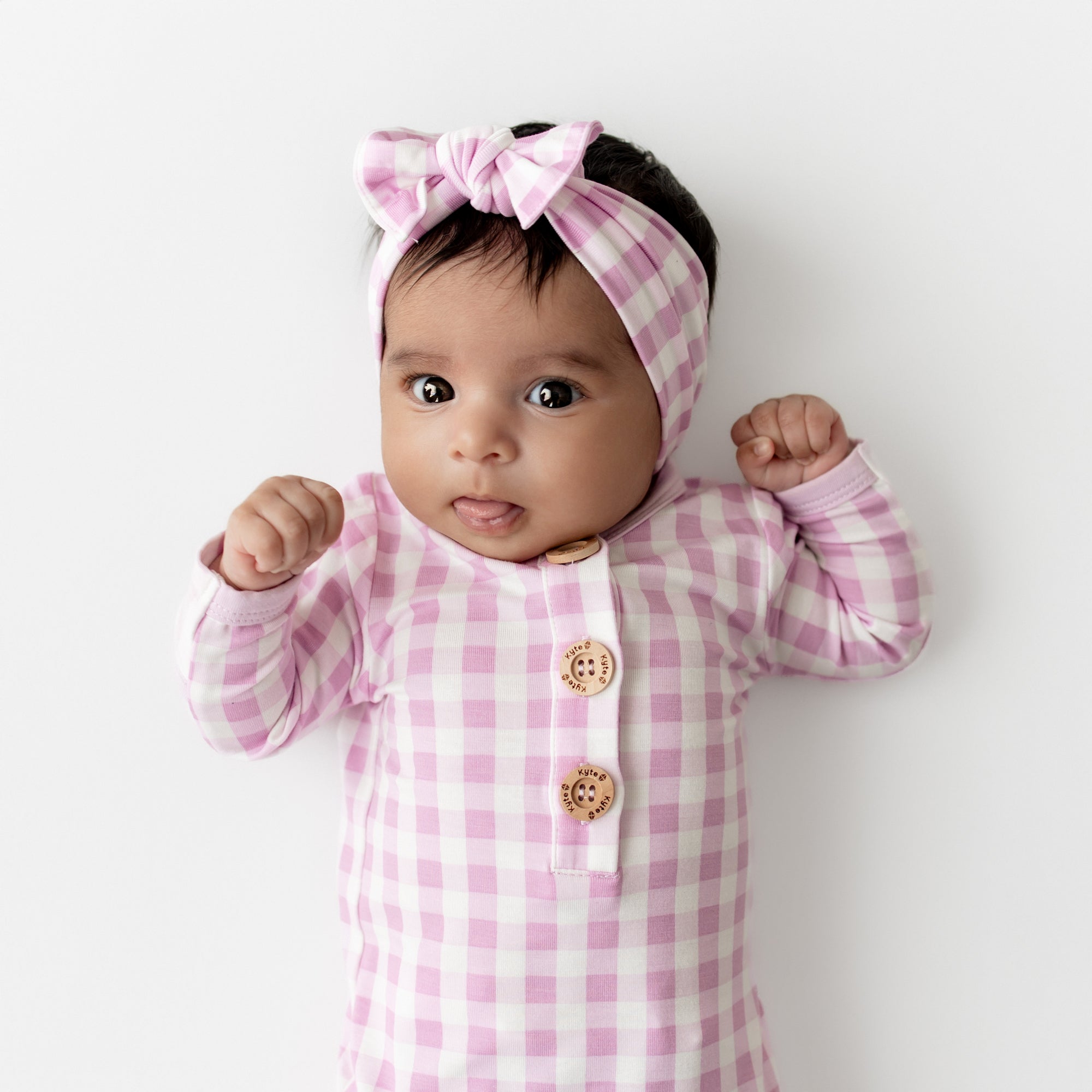 Close up of infant wearing the Knotted Gown with Bow Set in Gingham Thistle