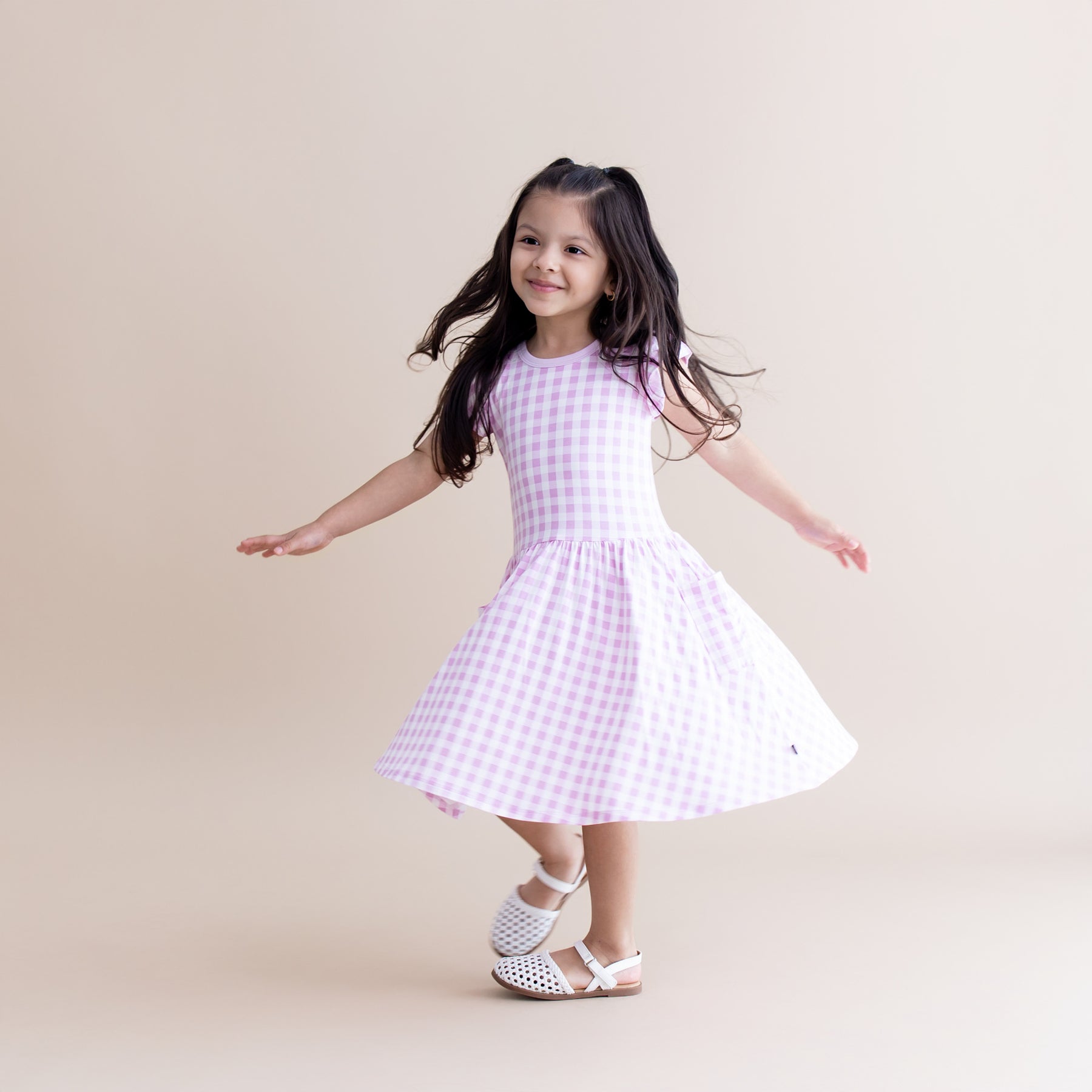 Young girl model twirling in the Pocket Dress in Gingham Thistle 