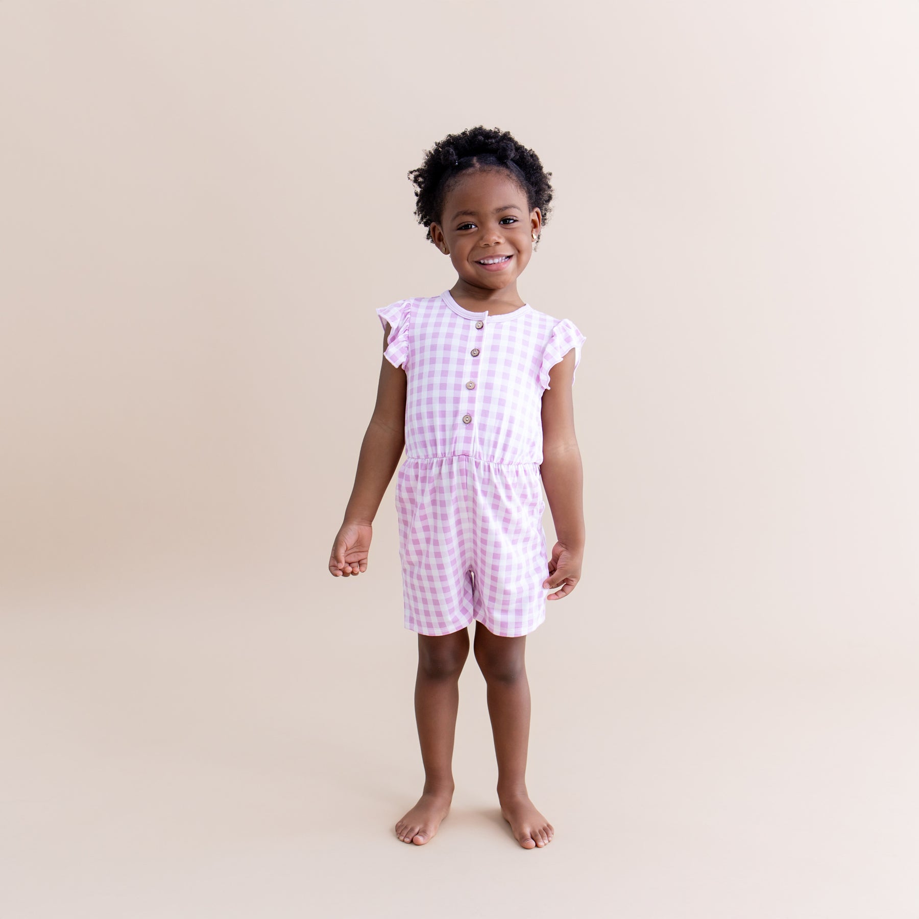 Young girl modeling the Flutter Sleeve Romper in Gingham Thistle