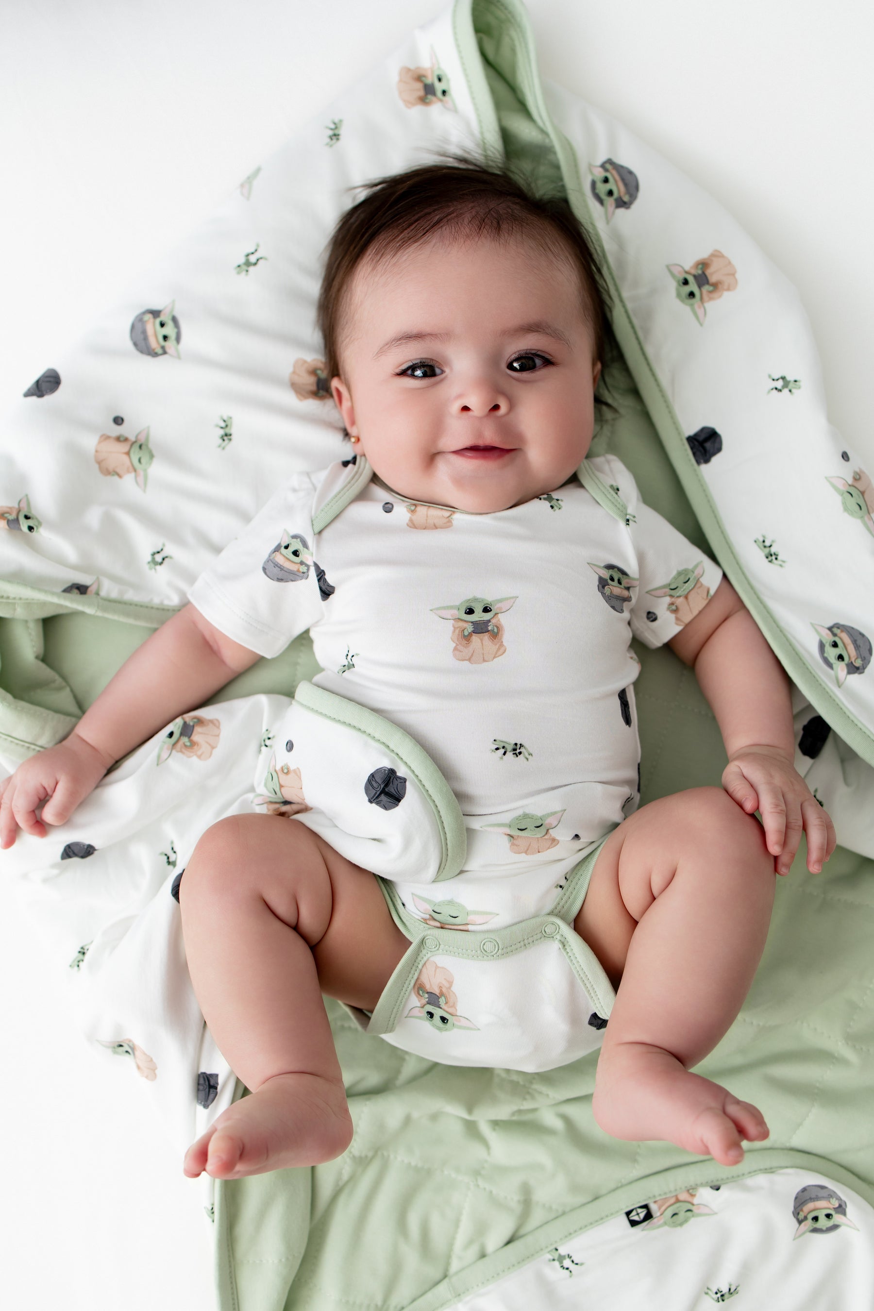 Close up of infant laying on a Baby Blanket in Grogu™ wearing a matching short sleeve bodysuit