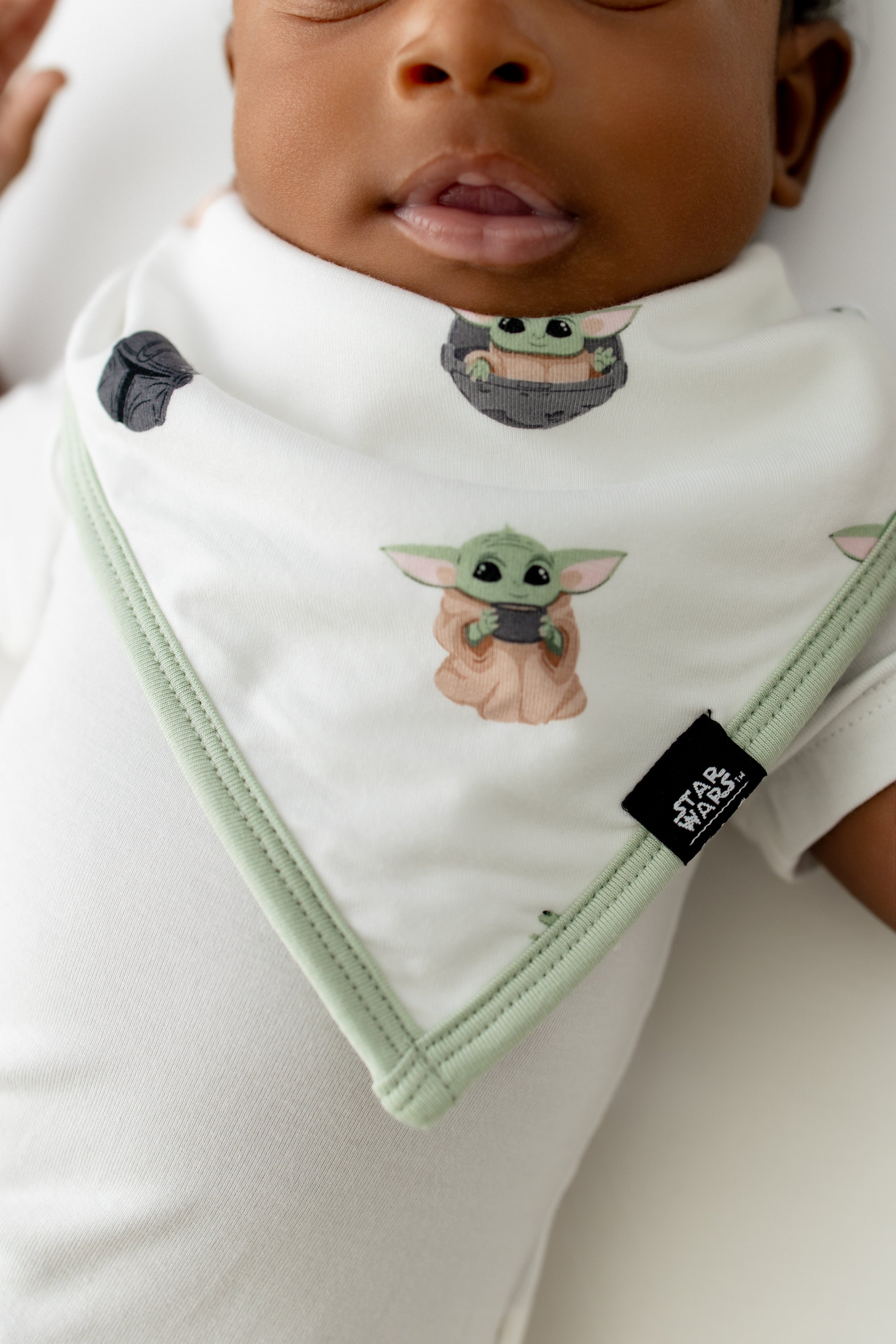 Close up of the Bib in Grogu™ on an infant with the Kyte Baby | STAR WARS™ black logo tag