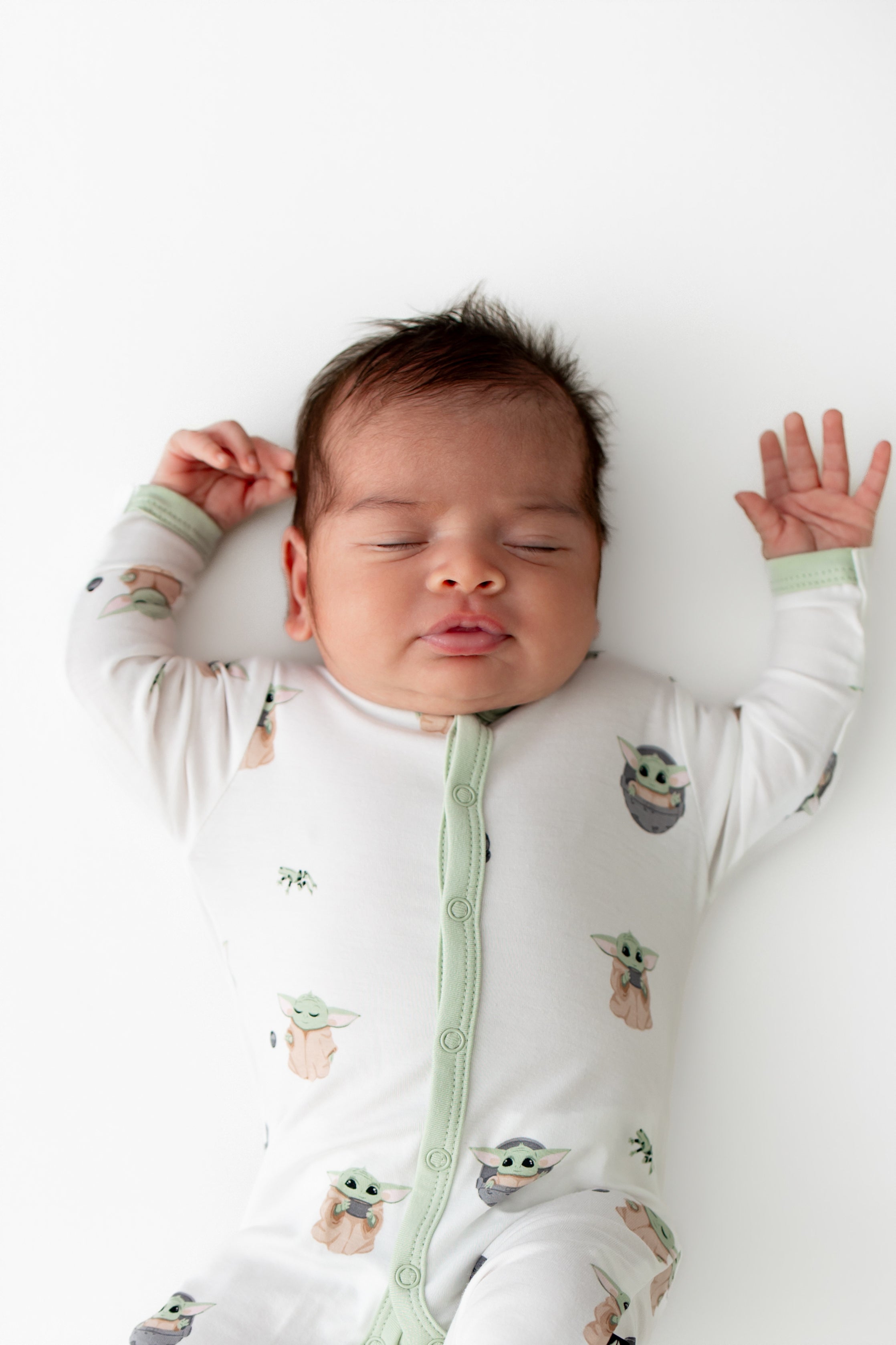 Close up of newborn wearing the Romper in Grogu™ showing the light green trim at the snap closures and wrist trim