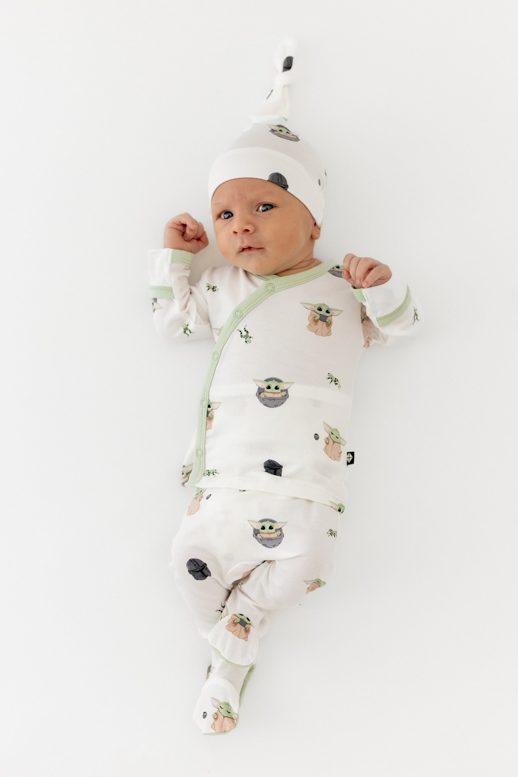 Newborn wearing the Take Me Home Set with Cap in Grogu™ on a white surface