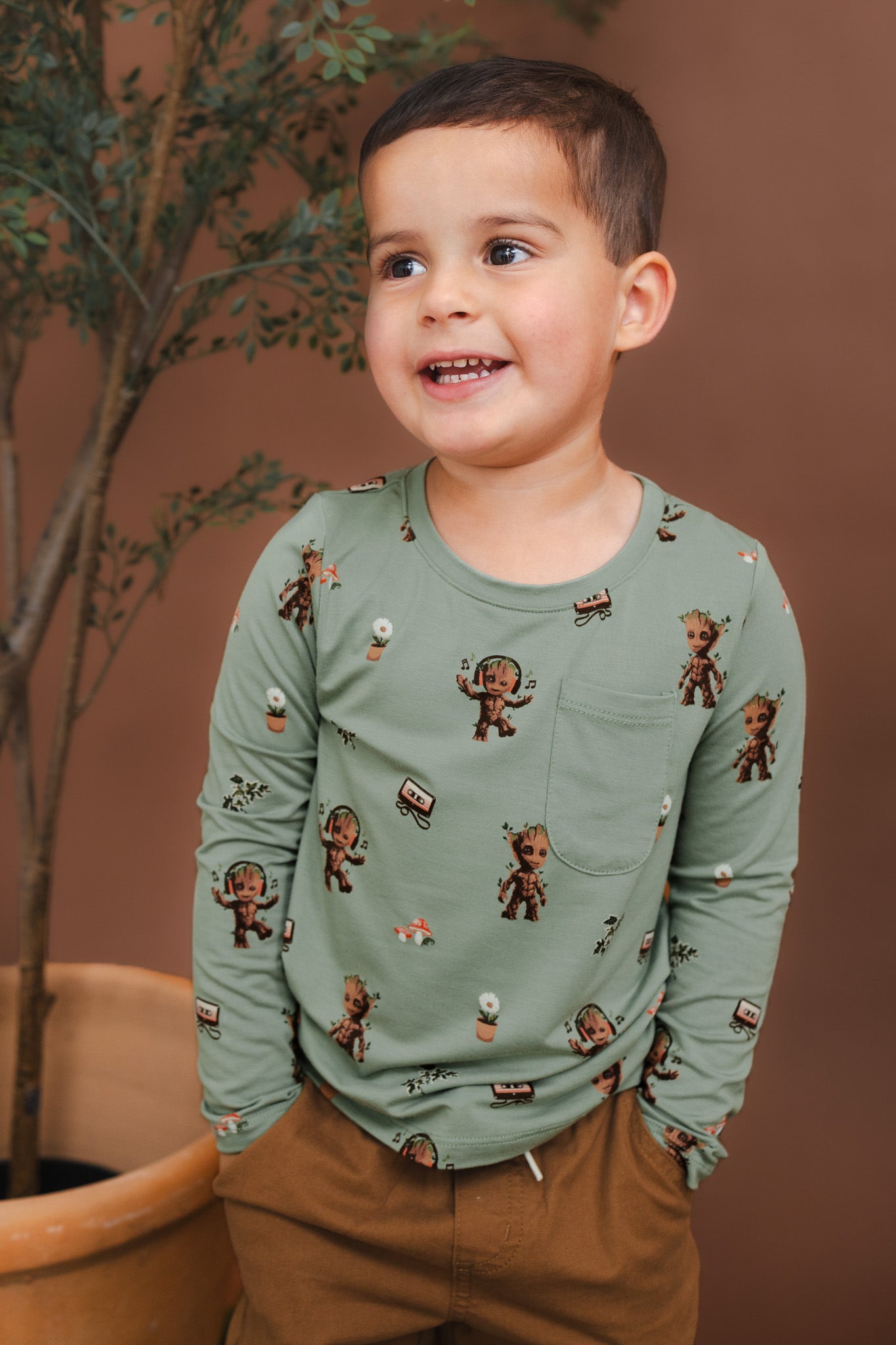 Boy wearing Green Long Sleeve Toddler Crew Neck Tee in Groot print over brown pants