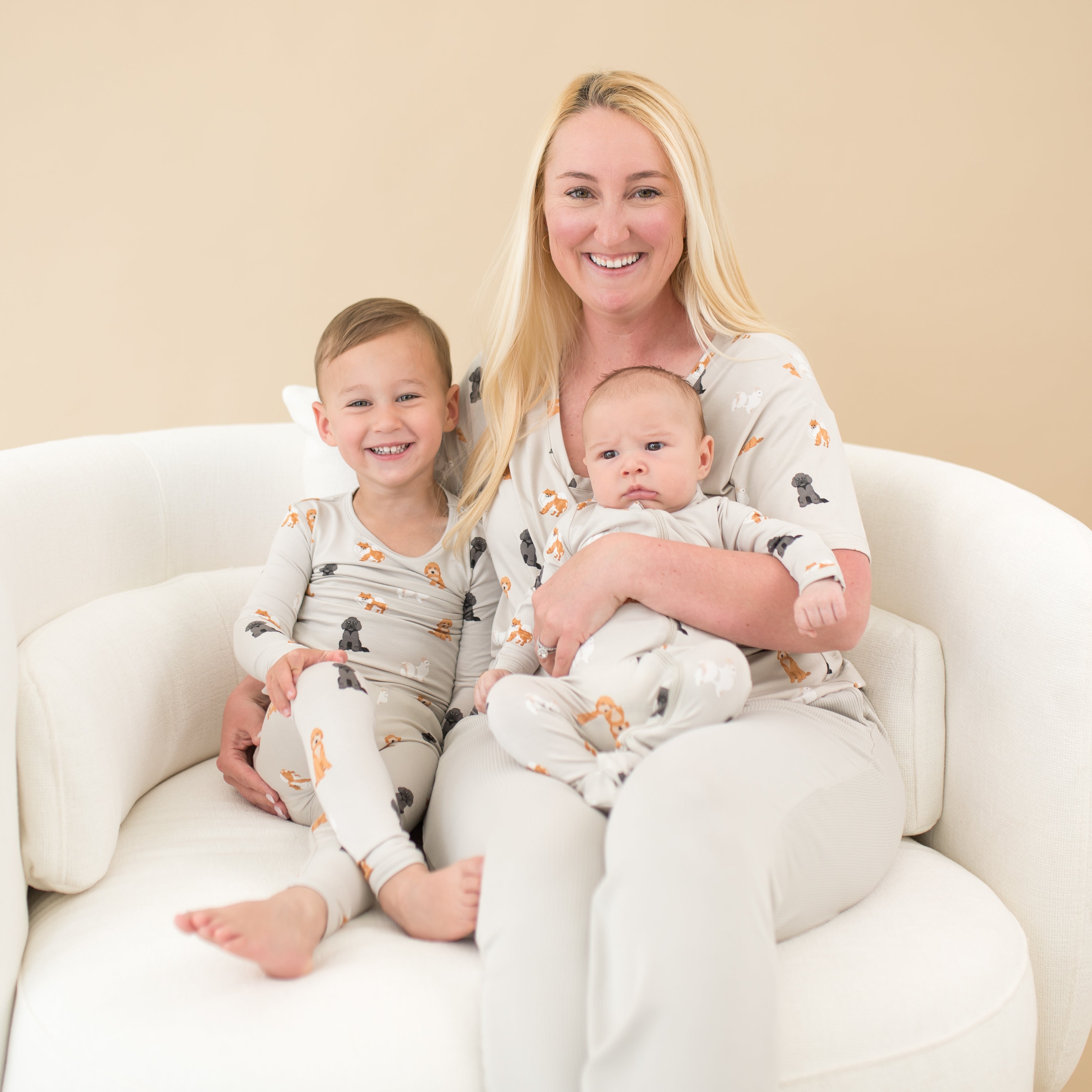 Family of three sitting on a cream round sofa matching in Fluffy Dog