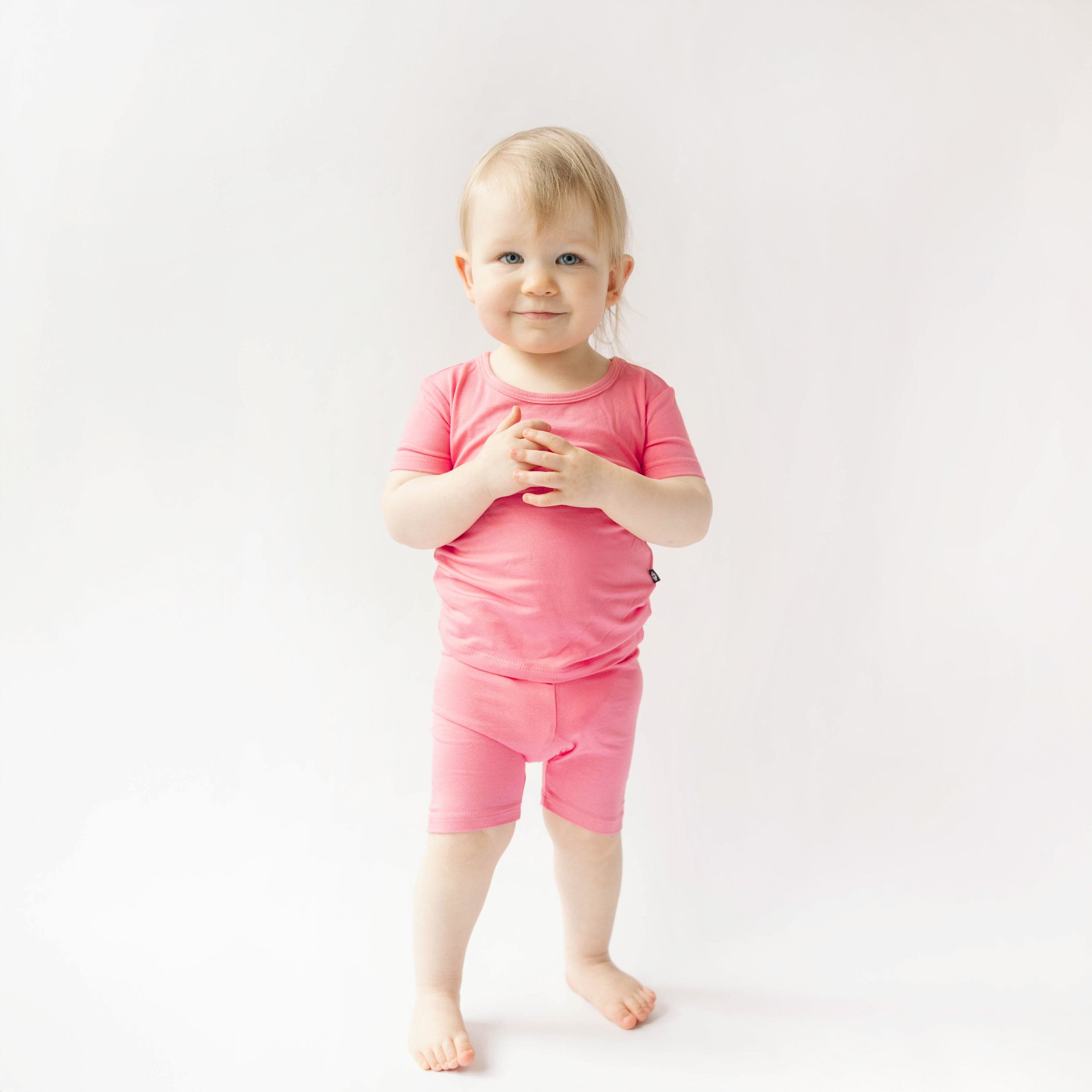 toddler wearing kyte baby short sleeve pajamas in guava 