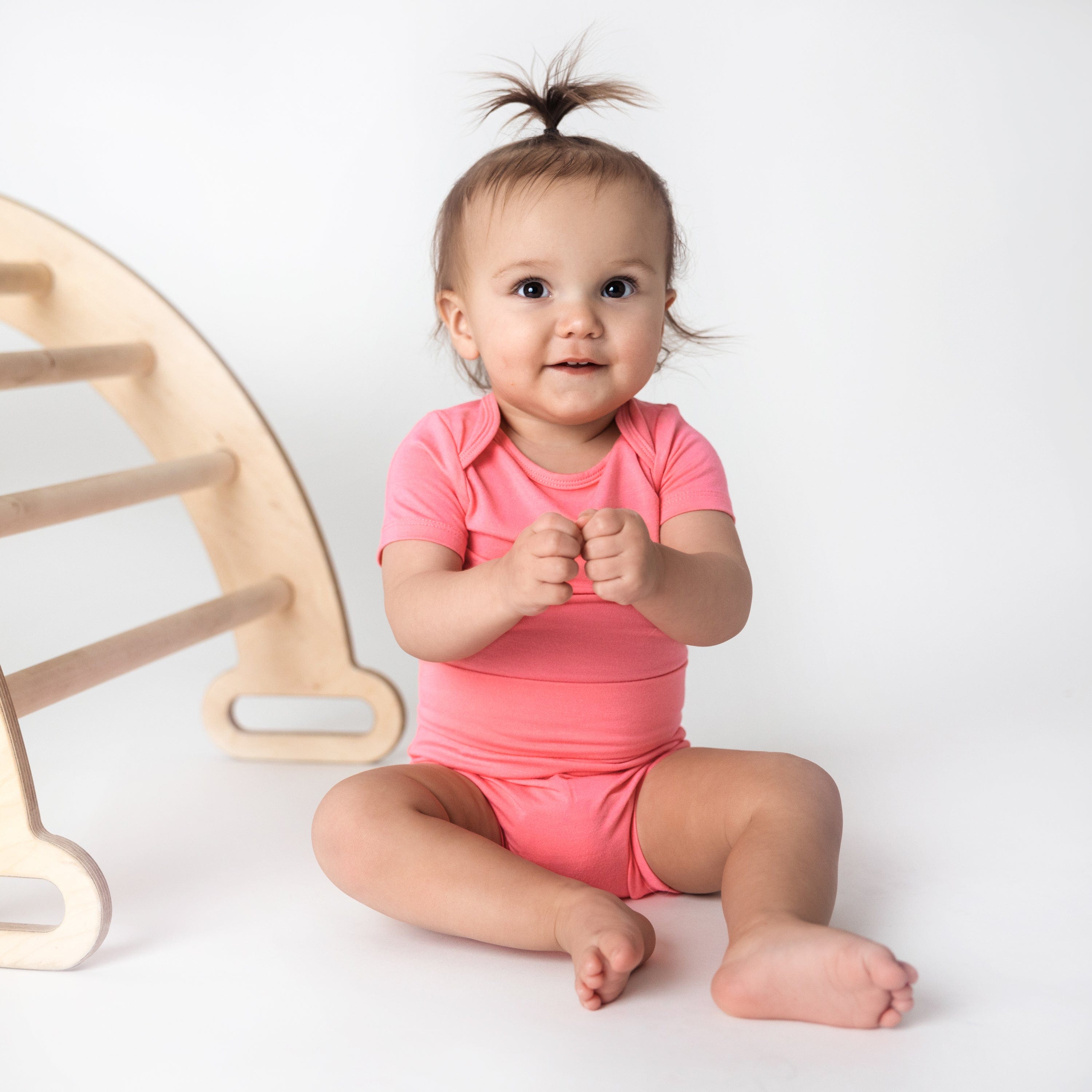 toddler wearing guava short sleeve bodysuit and bummies 