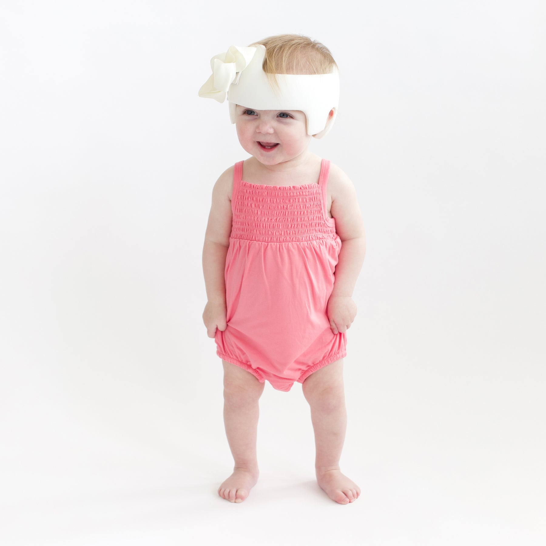 Toddler modeling Smocked Bubble Romper in Guava