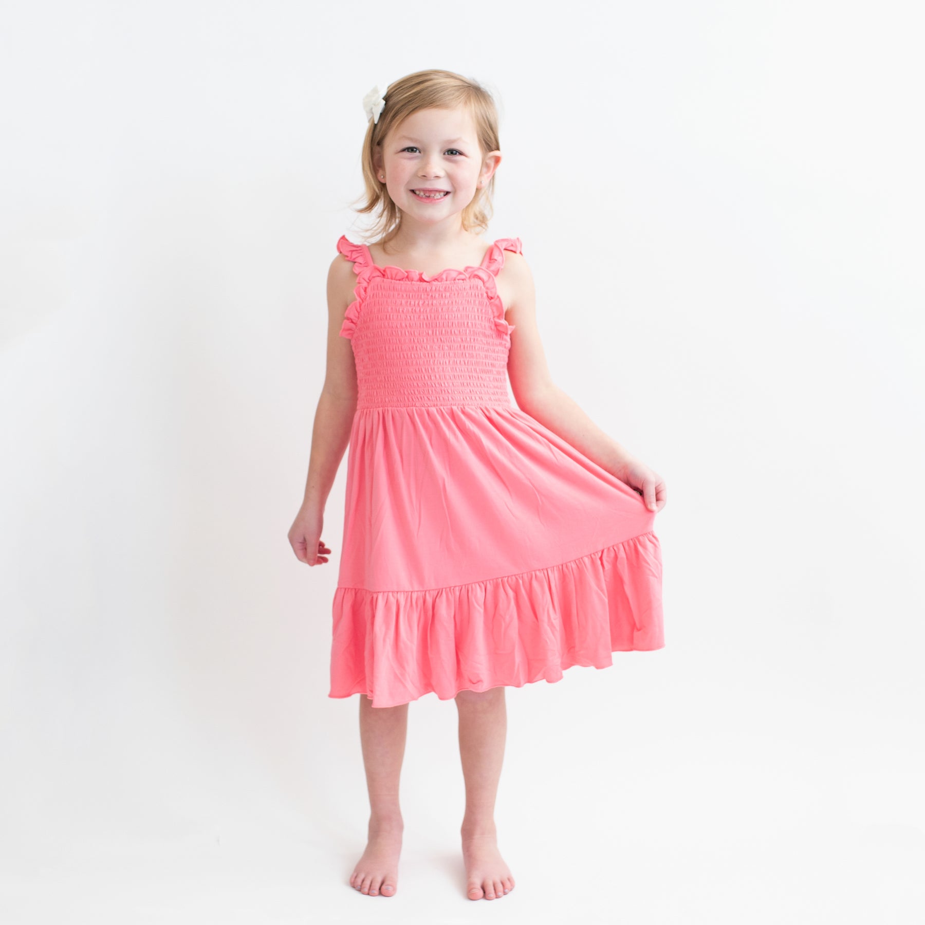 Child modeling Smocked Dress in Guava