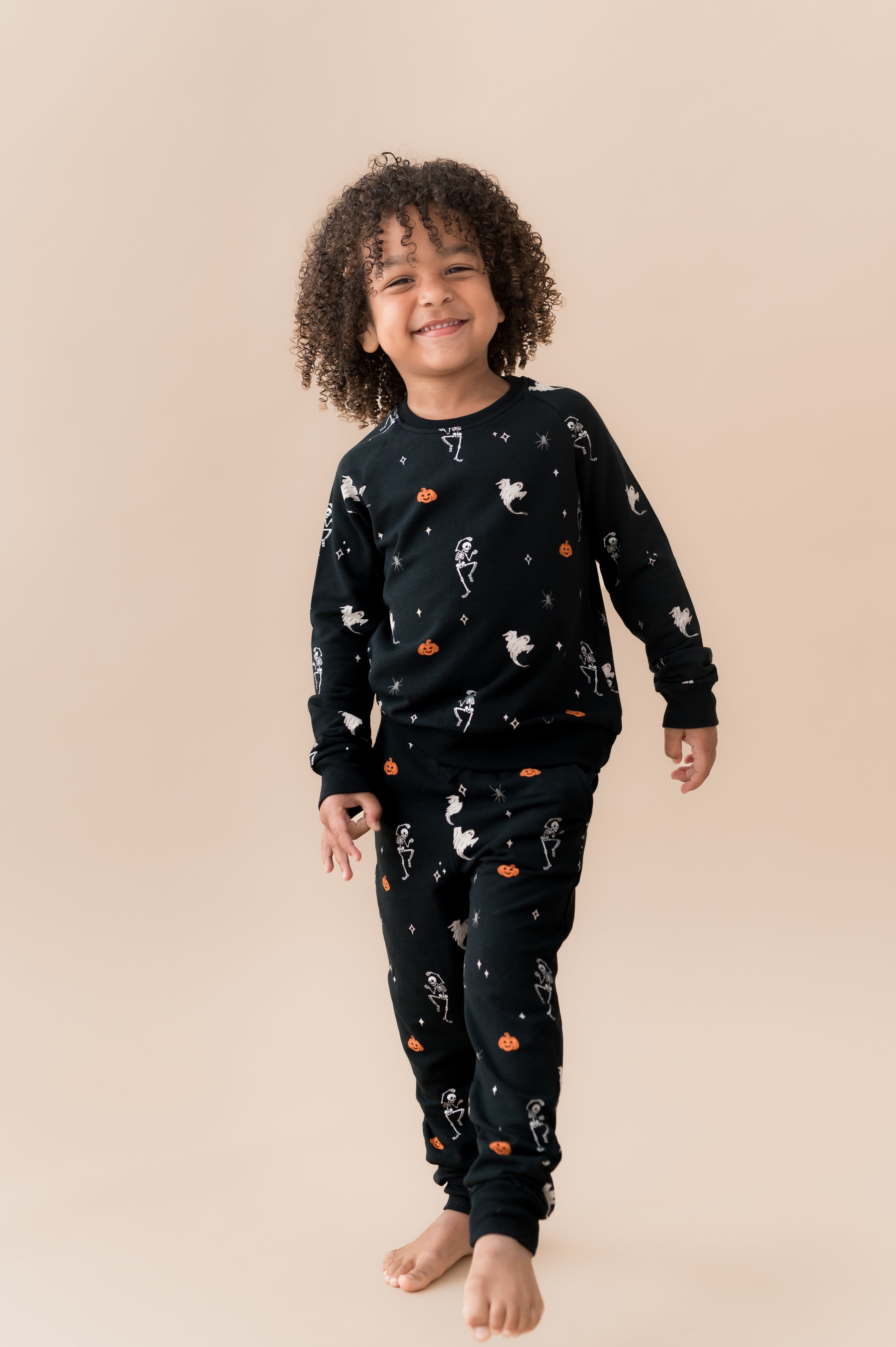 Boy wearing Long Sleeve Jogger Set in Halloween Friends print on a beige background