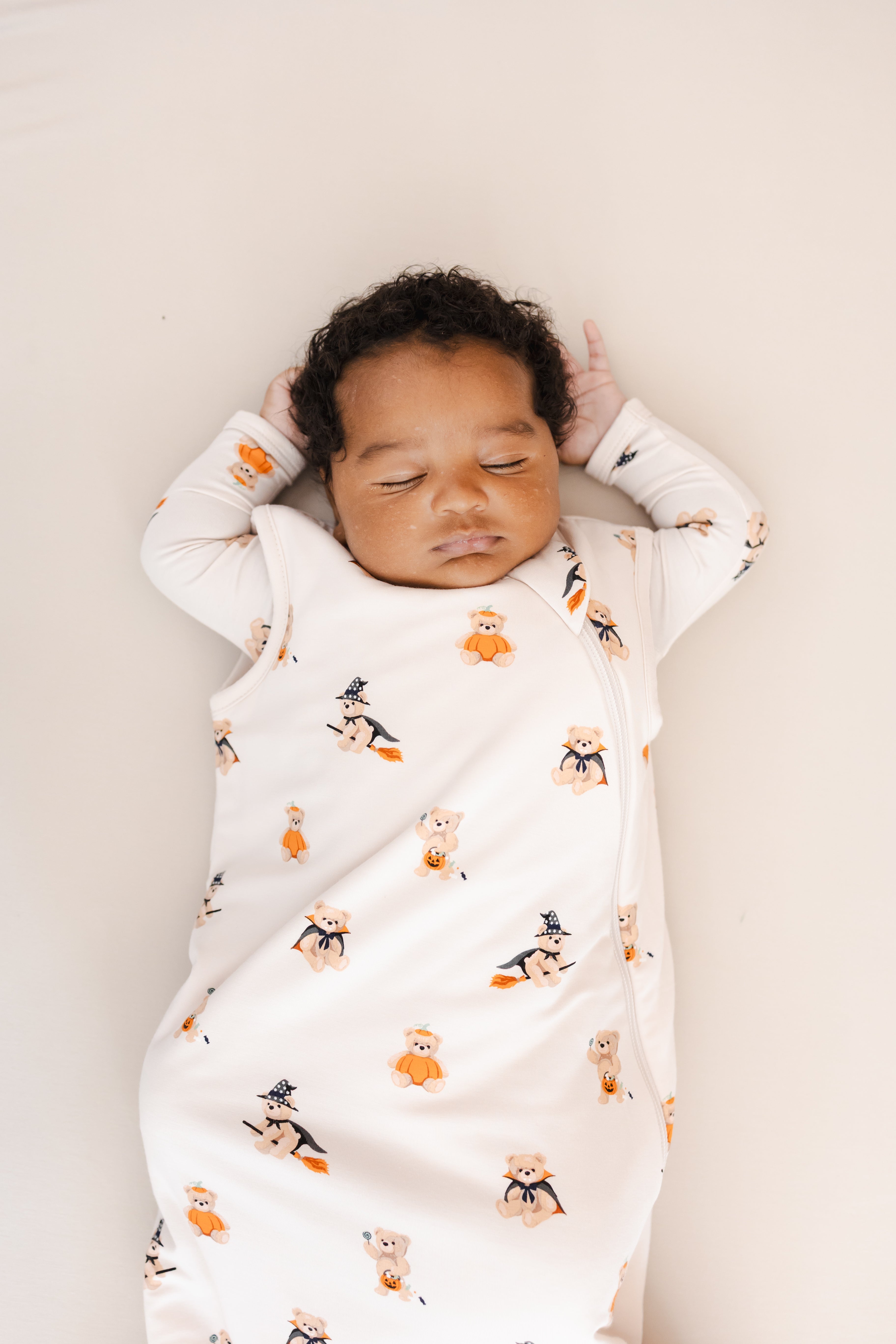 Close up of Baby sleeping in Sleep Bag in Halloween Teddy 1.0 print on a beige background