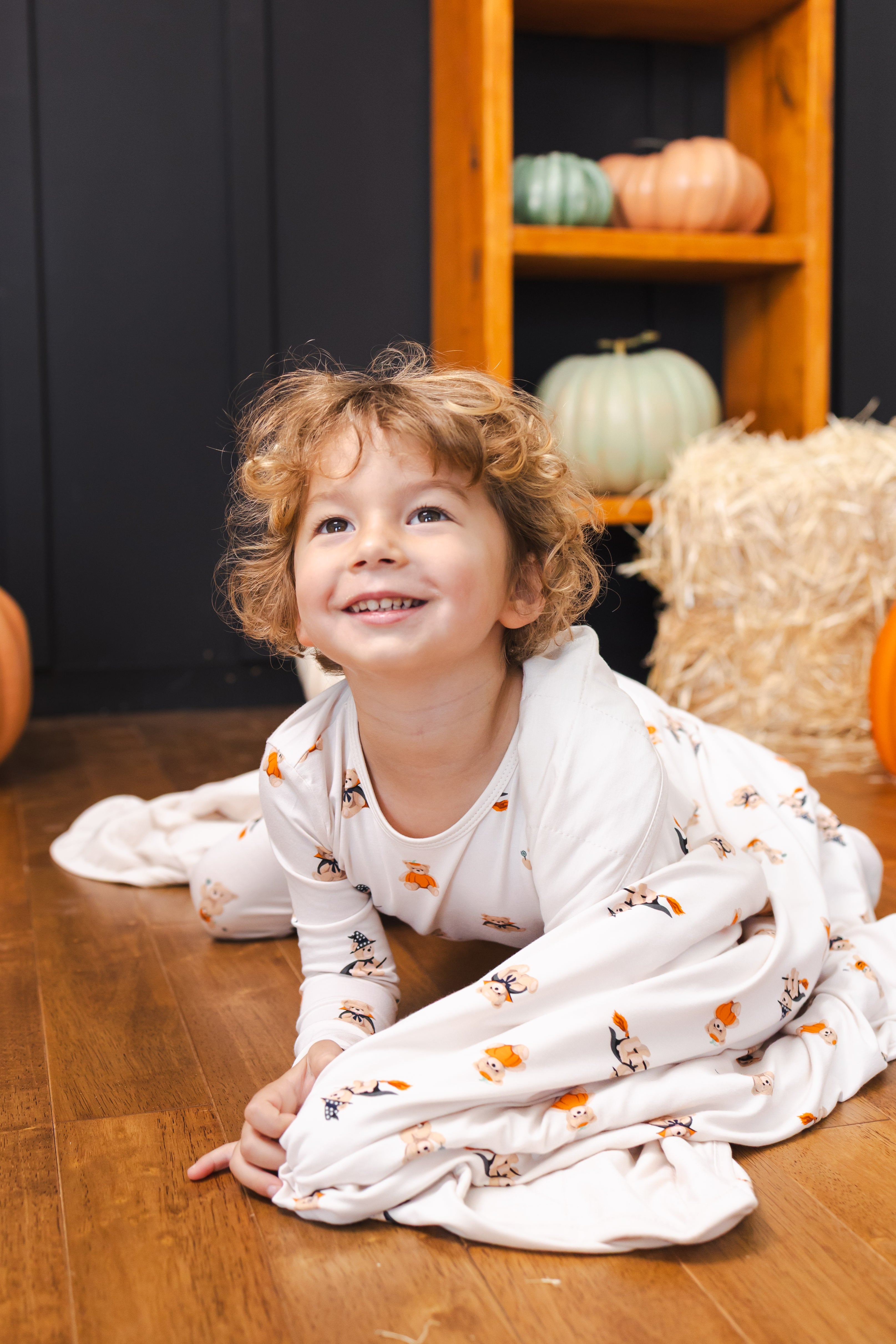 Boy with Toddler Blanket in Halloween Teddy 1.0 print wearing a similar print long sleeve pajama set
