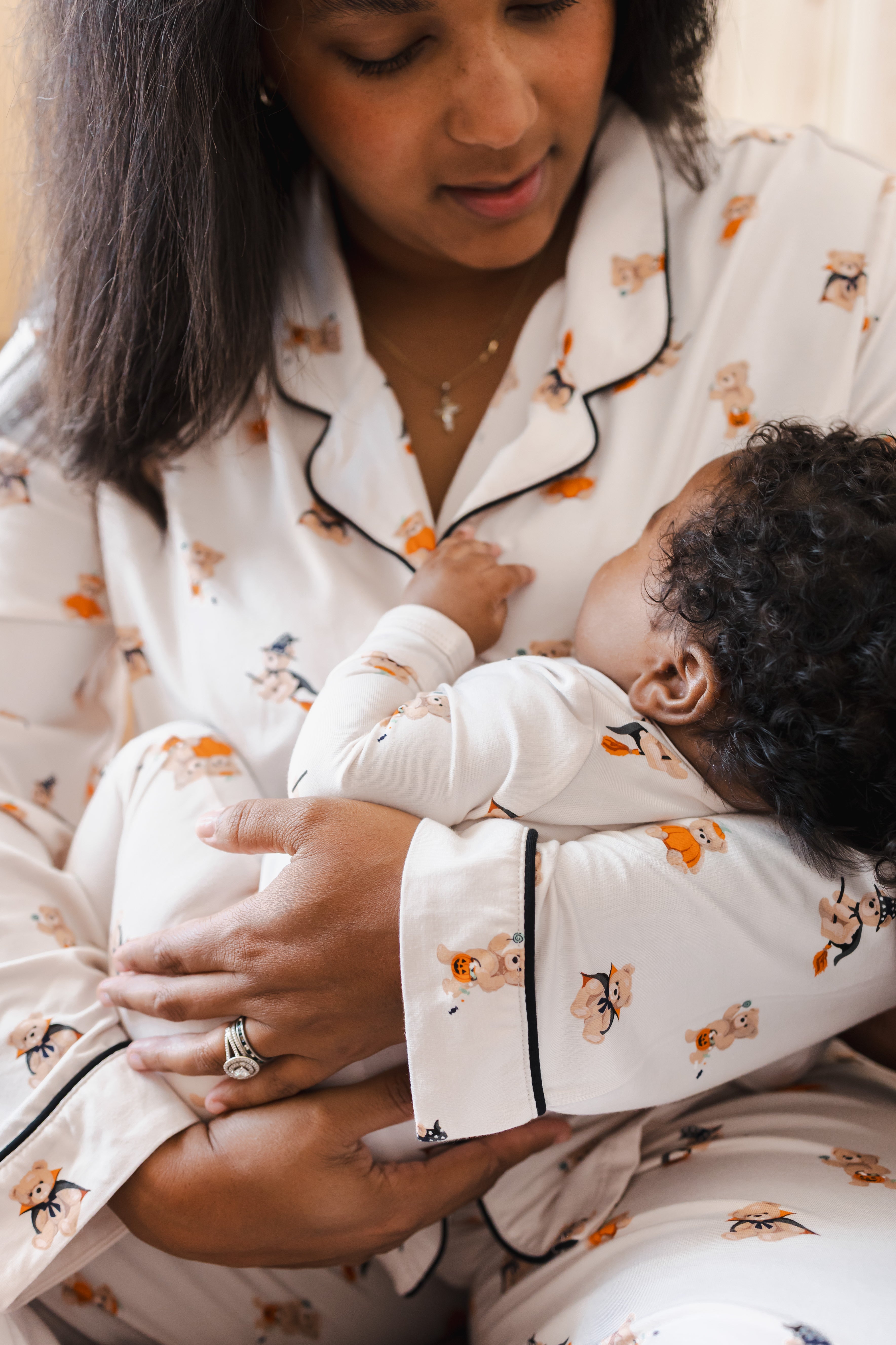 Close up of Mother and baby wearing Matching Long sleeve Women's pajama set and zippered footie in Halloween Teddy print 