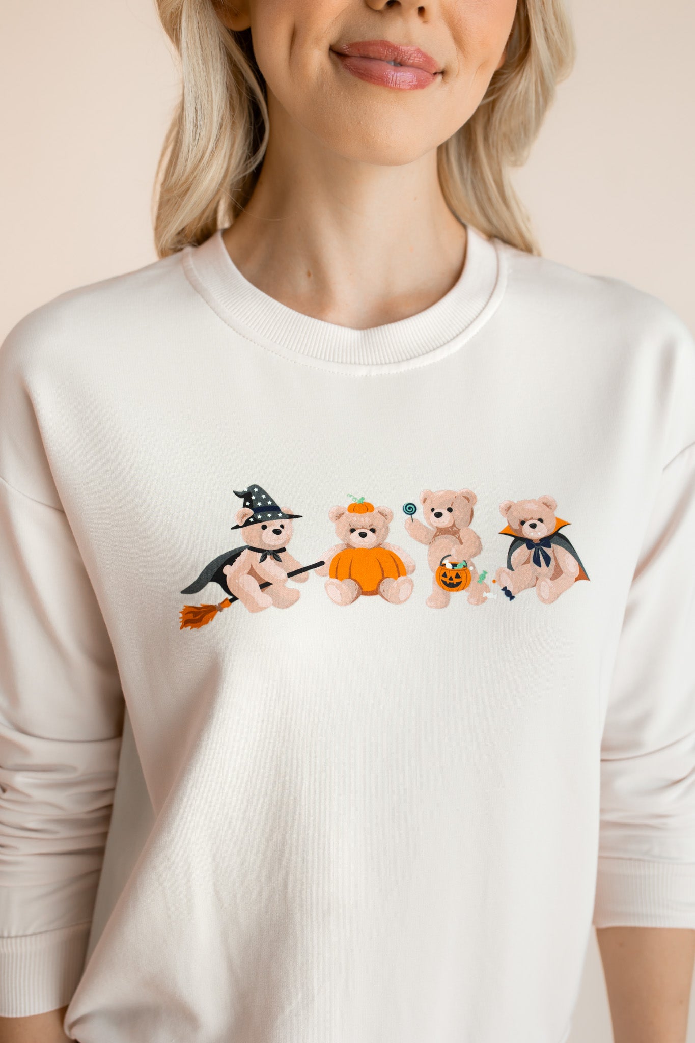 Close up of Modal wearing off white Women's Sweatshirt with Halloween Teddy print in the center