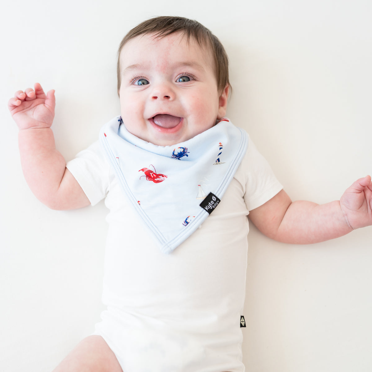 Infant wearing Bib in Harbor over white onesie
