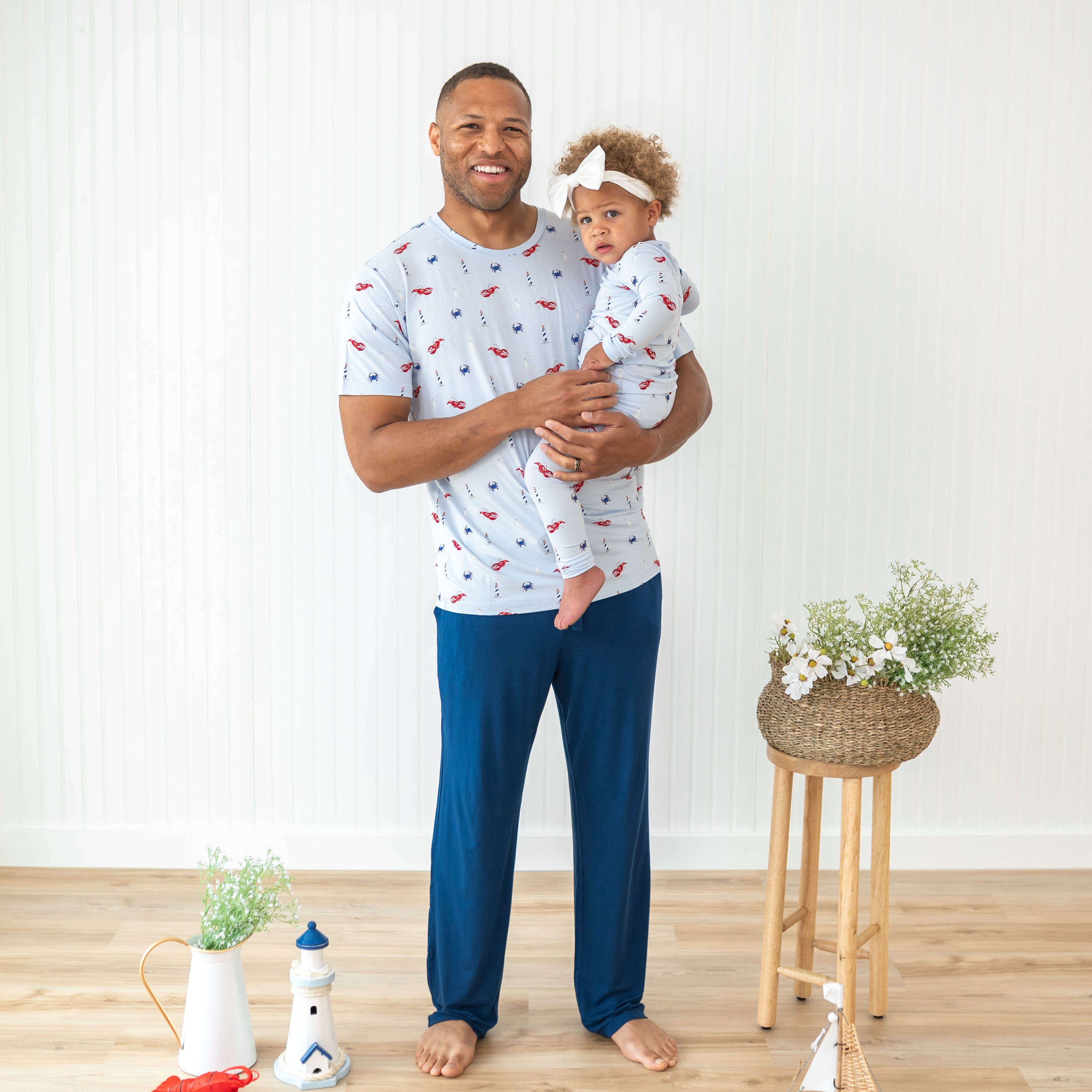 Father wearing the Men's Crew neck tee holding his daughter who is matching in Long Sleeve Pajamas in Harbor