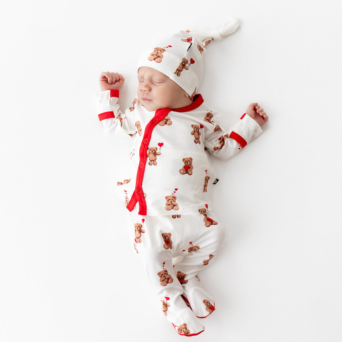 Sleeping newborn wearing the breathable and soft Take Me Home Set with Cap in Bear Hearts