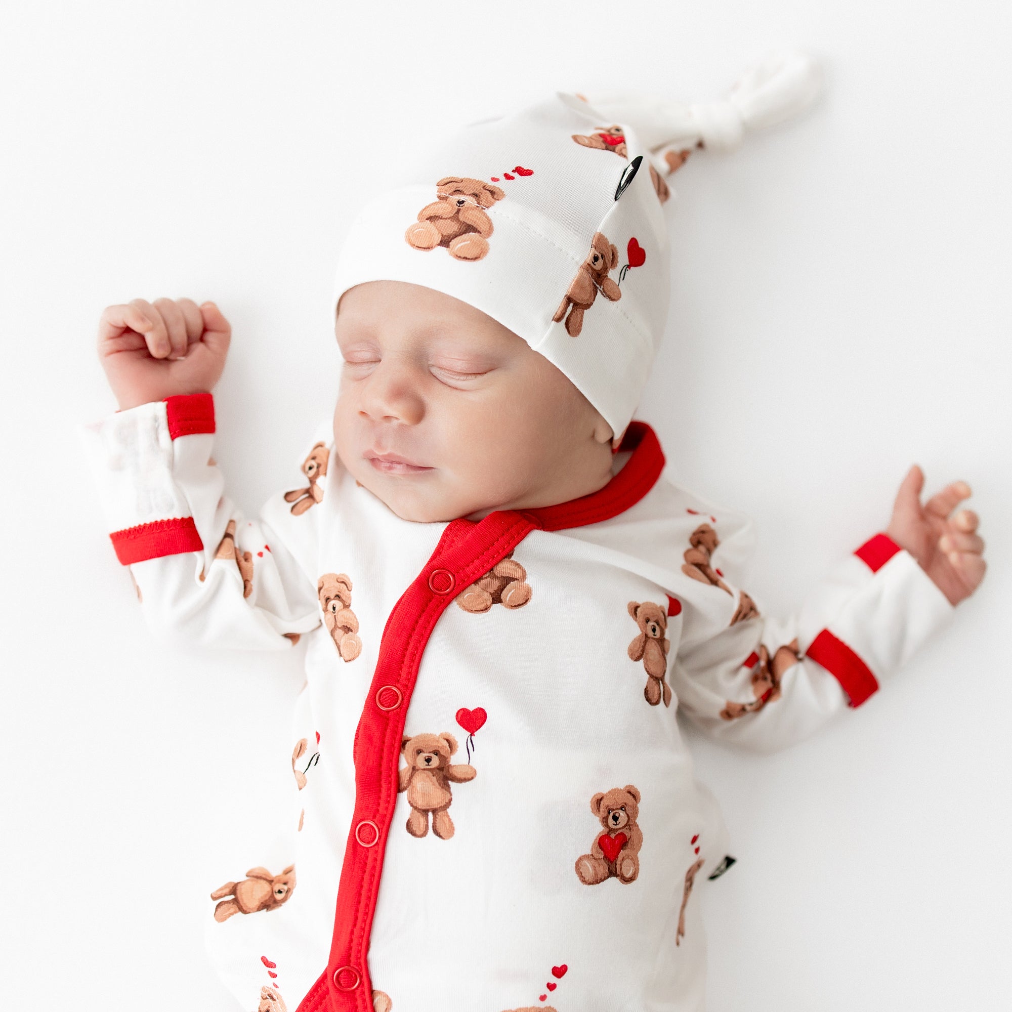 Close up of sleeping newborn wearing the Take Me Home Set with Cap in Bear Hearts
